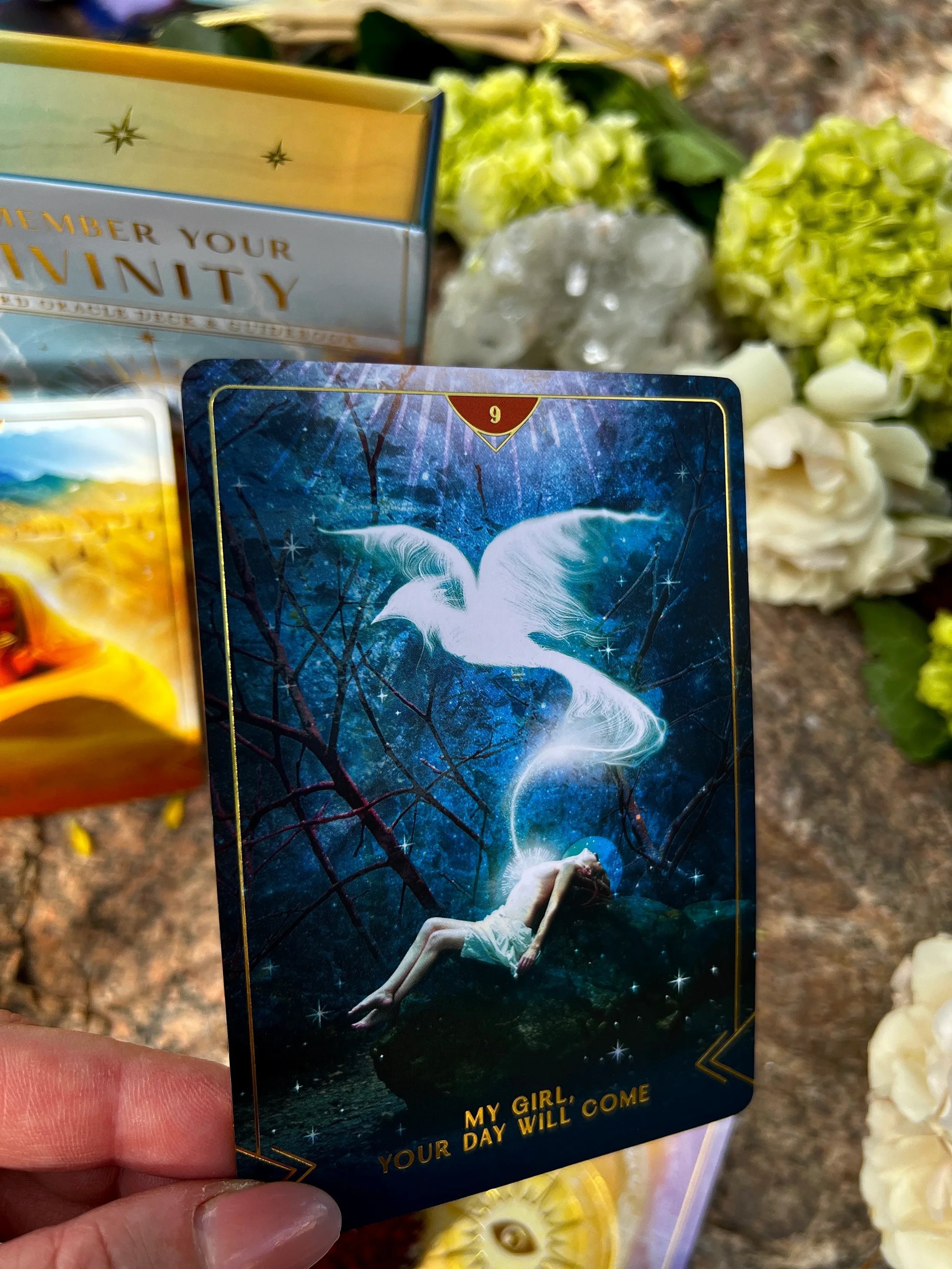 A tarot card featuring a woman lying on a rock with a ghostly white dove flying above her, surrounded by a mystical, starry background. The card has the message 'My girl, your day will come' at the bottom.