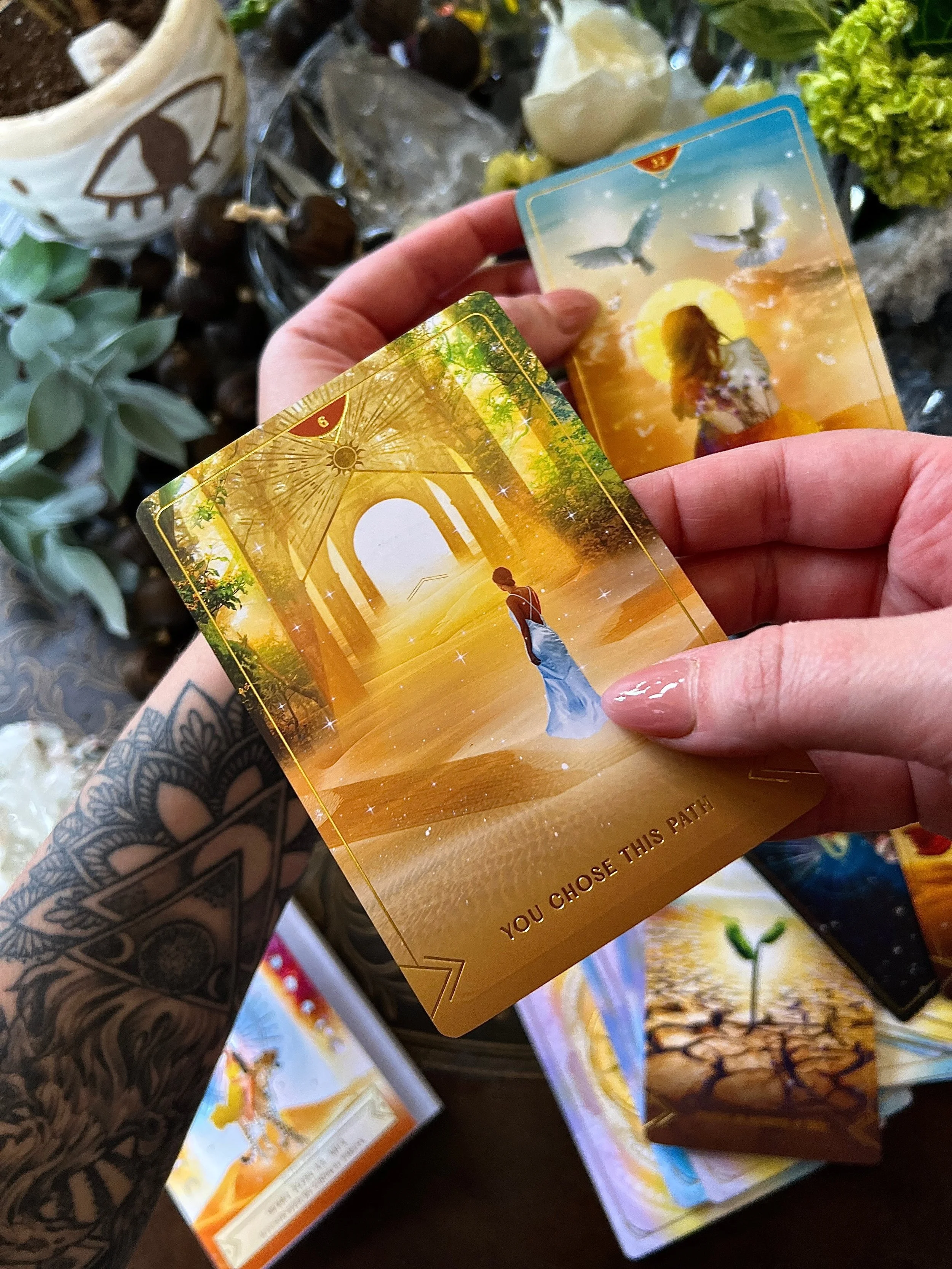 Tarot card showing a woman standing on a path in a glowing, art deco styled landscape with arches and trees, with the text "You Chose This Path" at the bottom.