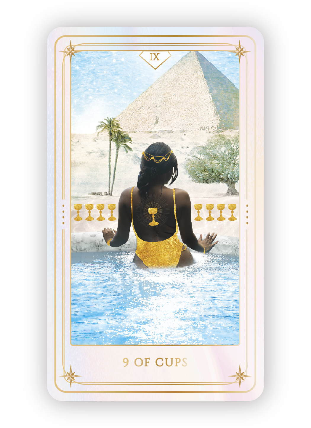 Tarot card titled '9 of Cups' featuring a woman with dark skin and black hair, adorned in golden jewelry, sitting in a pool facing a desert landscape with palm trees and the Pyramids of Egypt in the background.