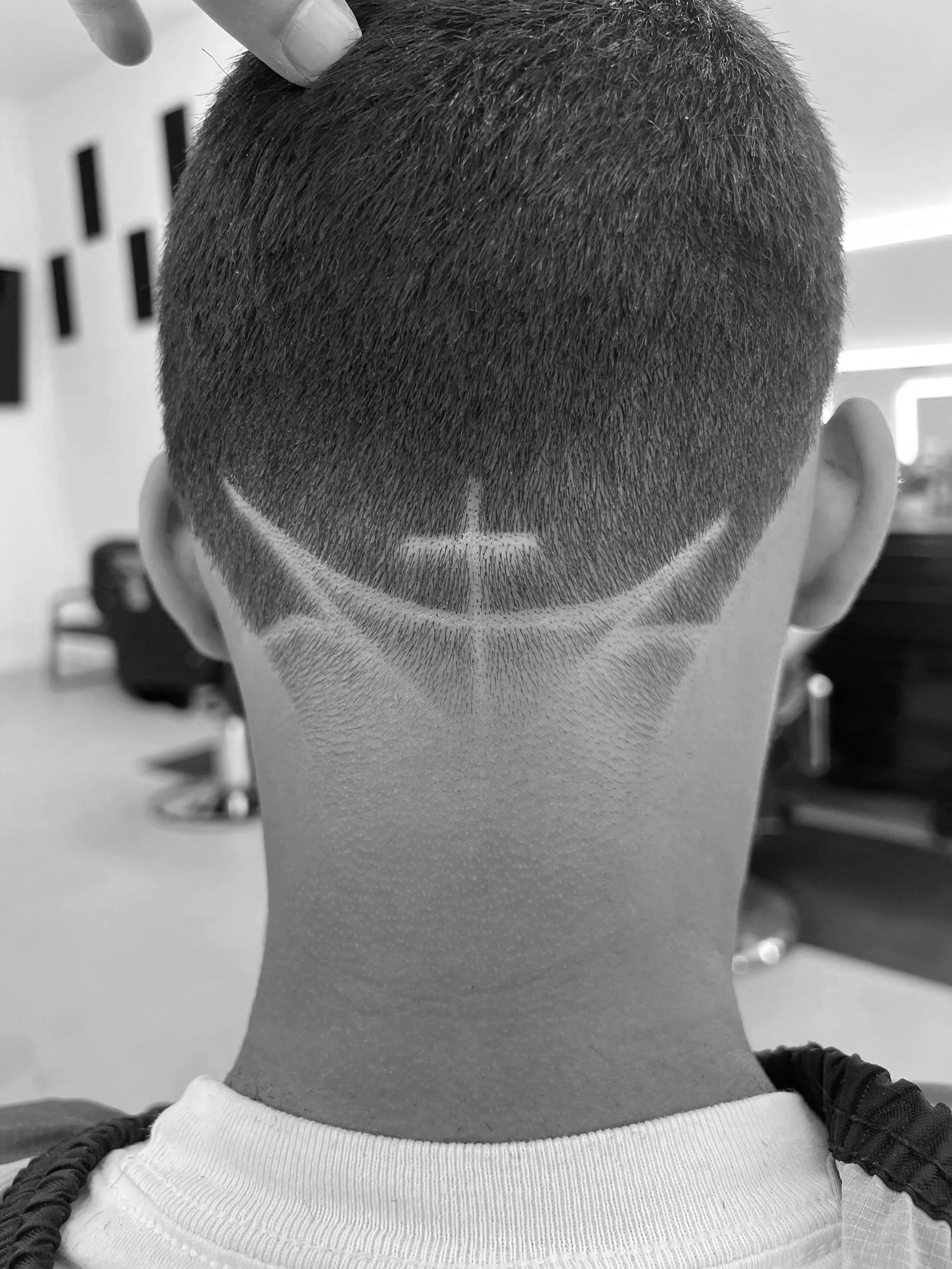 Back of a person's head with a fresh haircut that includes a shaved design featuring a Star Wars symbol.