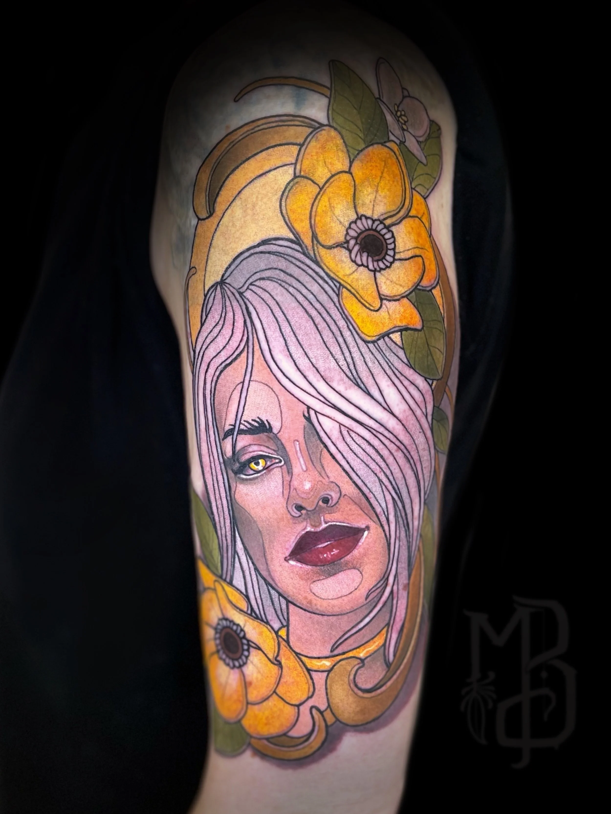 Tattoo of a woman's face with pink hair, done in neotraditional style, surrounded by yellow and orange flowers with green leaves.