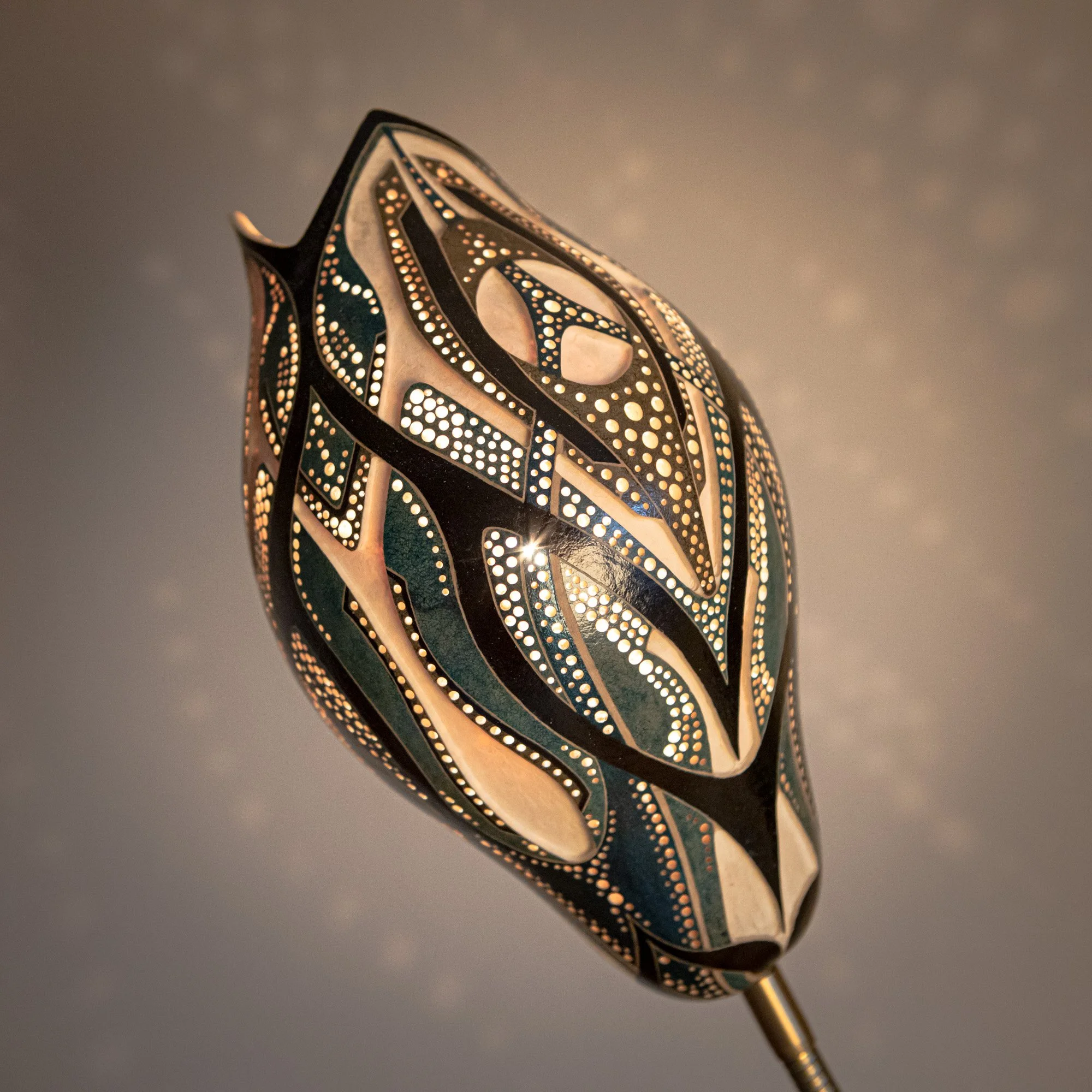 Kunstvoll gestaltete Lampenschirm mit detailliertem und farbigem Muster, beleuchtet.