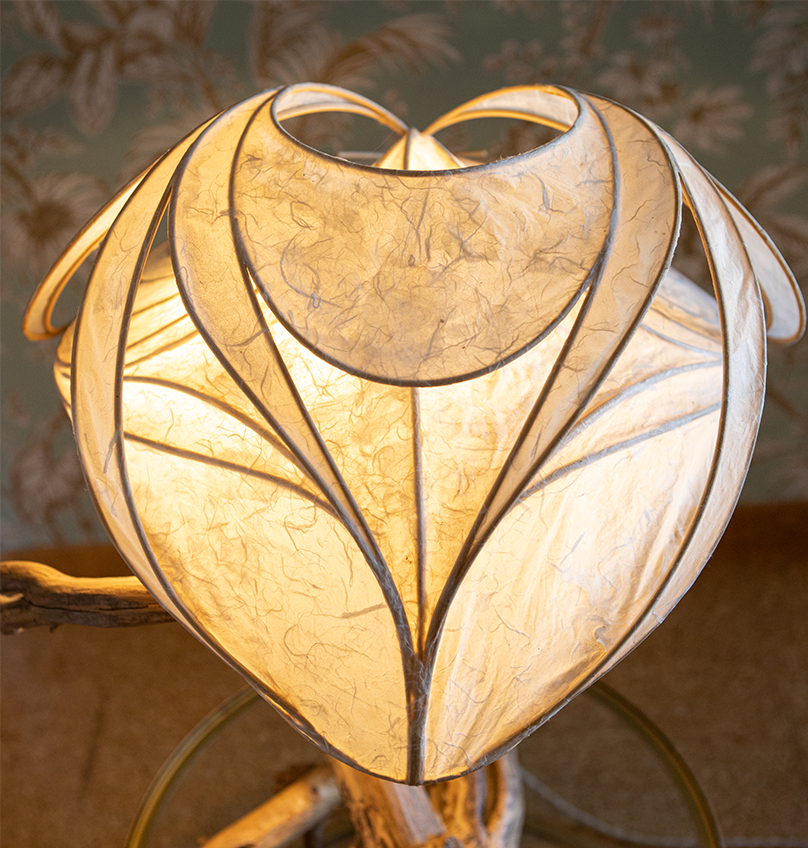 Eine dekorative Lampe mit einem Blatt- oder Herz-Motiv im warmen Licht.