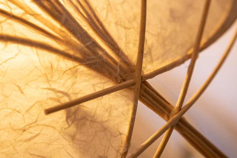 Nahaufnahme von einem beleuchteten Papierlaternen mit Holzgestell.