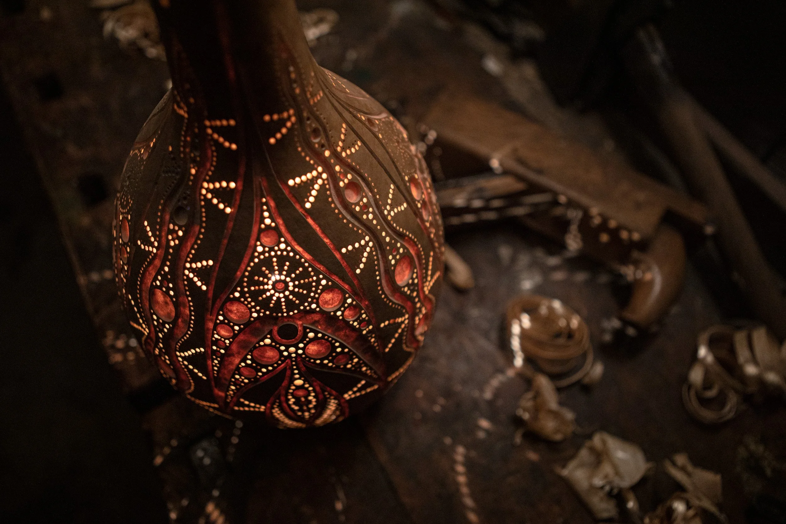 Osterdeko aus Holz mit Muster, beleuchtet, auf einem dunklen Tisch mit Holzspänen.