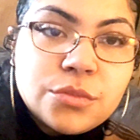 Close-up of a woman with glasses and dark hair.