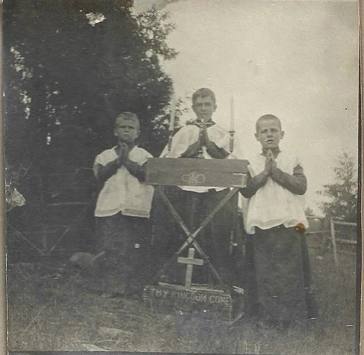 c1905-1906. Three boys practicing to be altar servers before the church was built. Under the direction of George VonTom