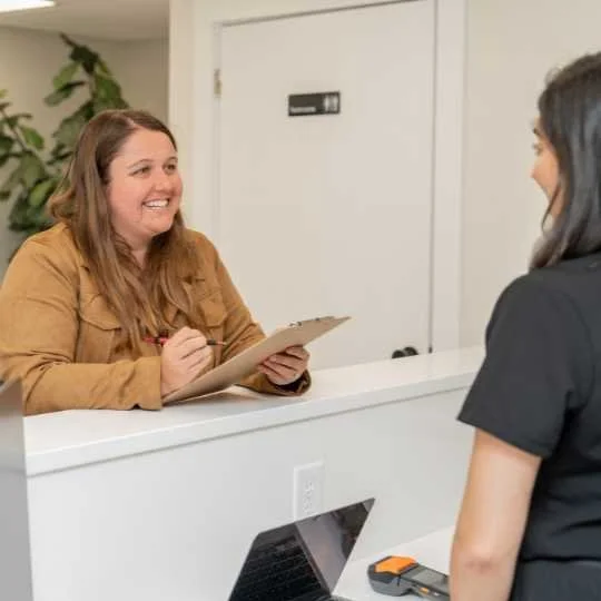 A patient checking in at Sansa’s reception desk
