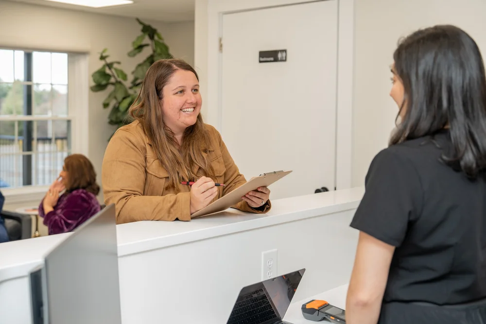 A visitor speaking with the Sansa Med Spa team at the reception desk.