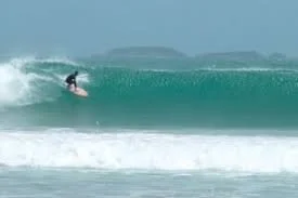 A person surfing on a wave in the ocean.