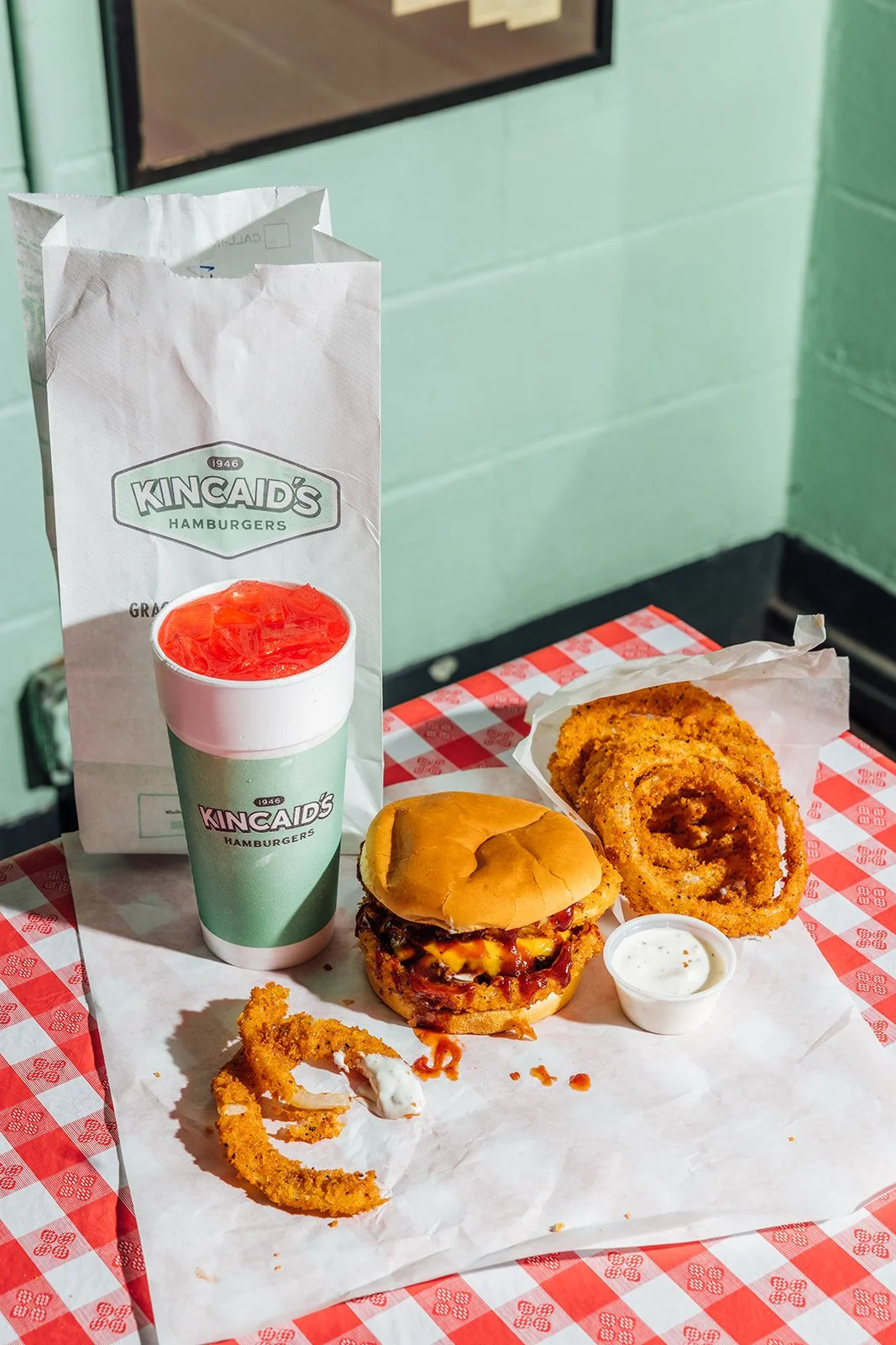 A Kincaid's meal with a delicious burger, homemade crispy onion rings, and a drink