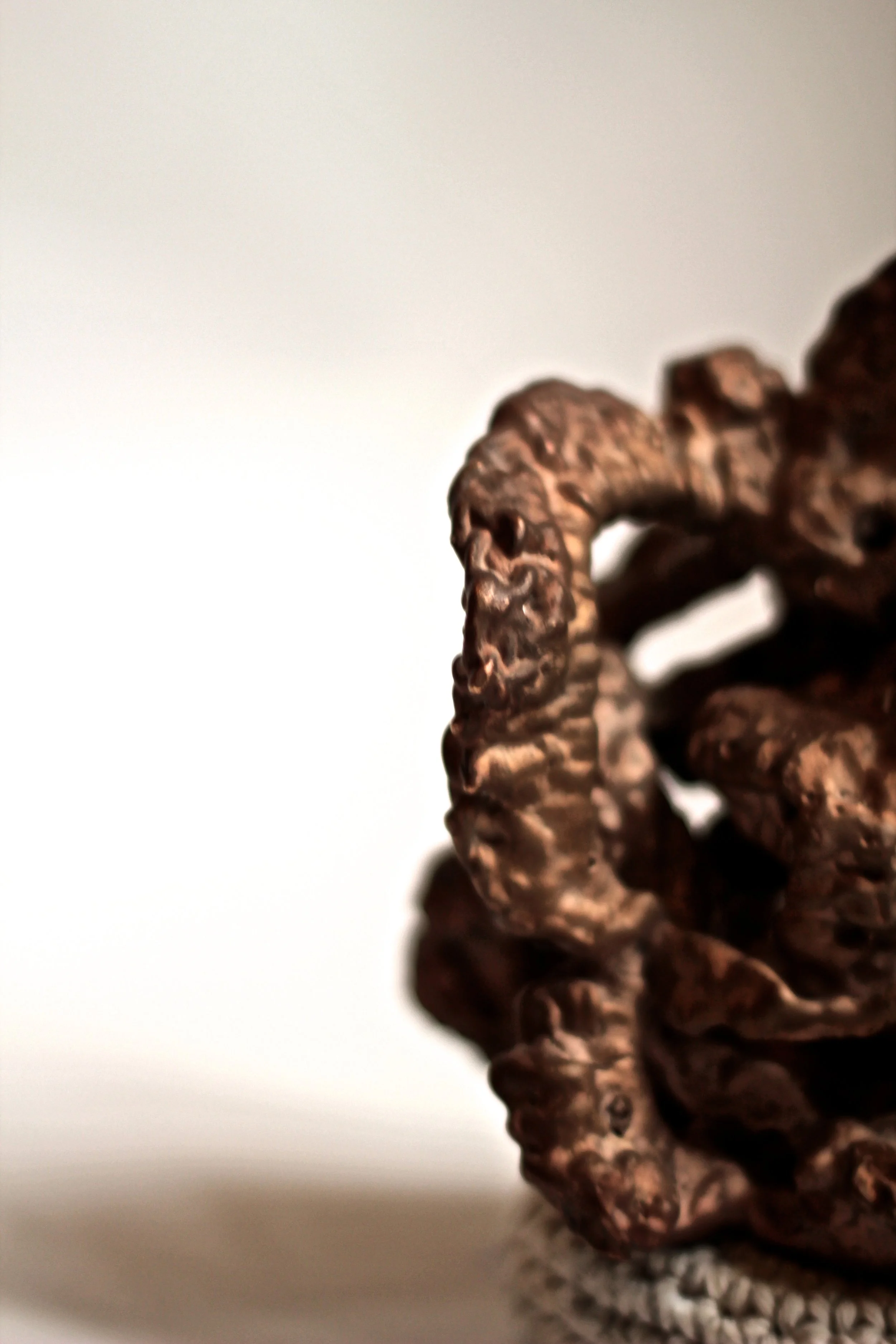 Close-up of a pile of dark chocolate cookies on a white surface.