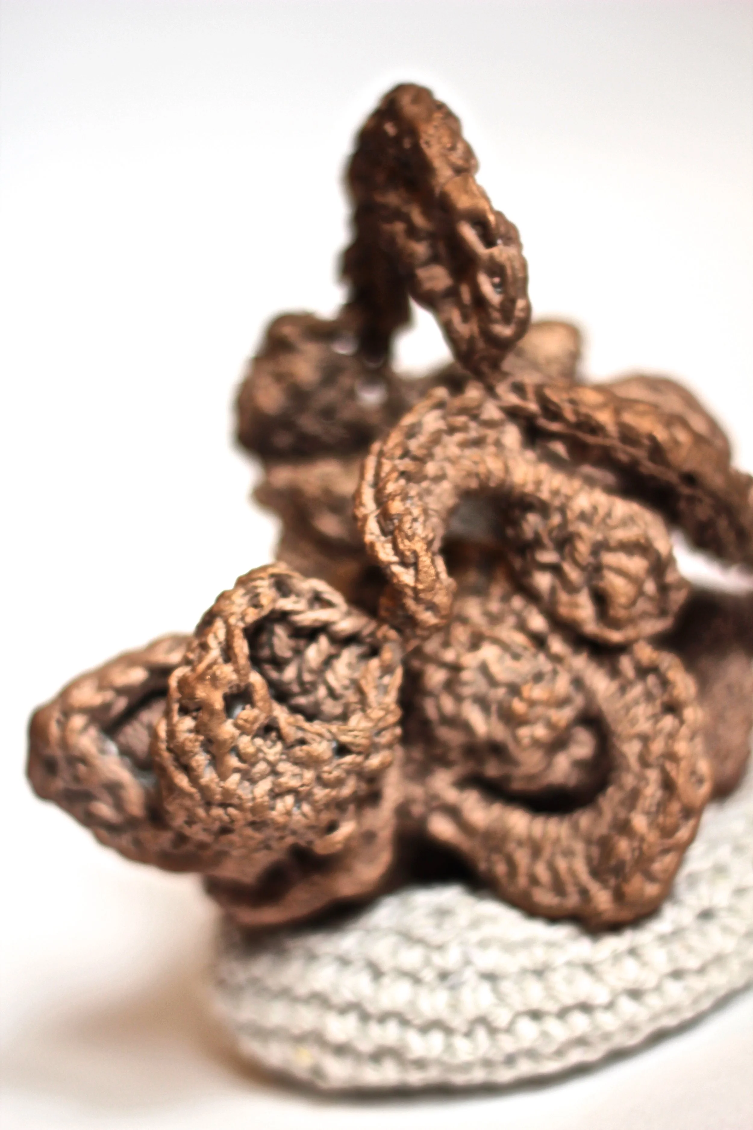 Close-up of a cluster of brown, textured taffy candies with a white background.