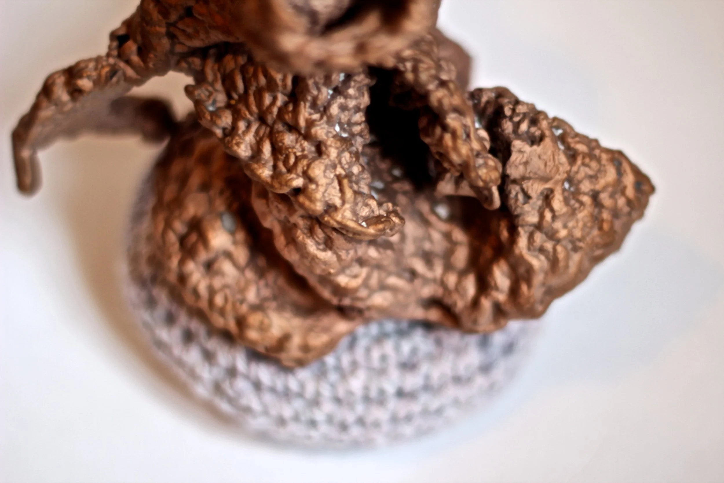 Close-up of a cluster of textured, brown, crispy-looking snacks or cookies on a white plate.