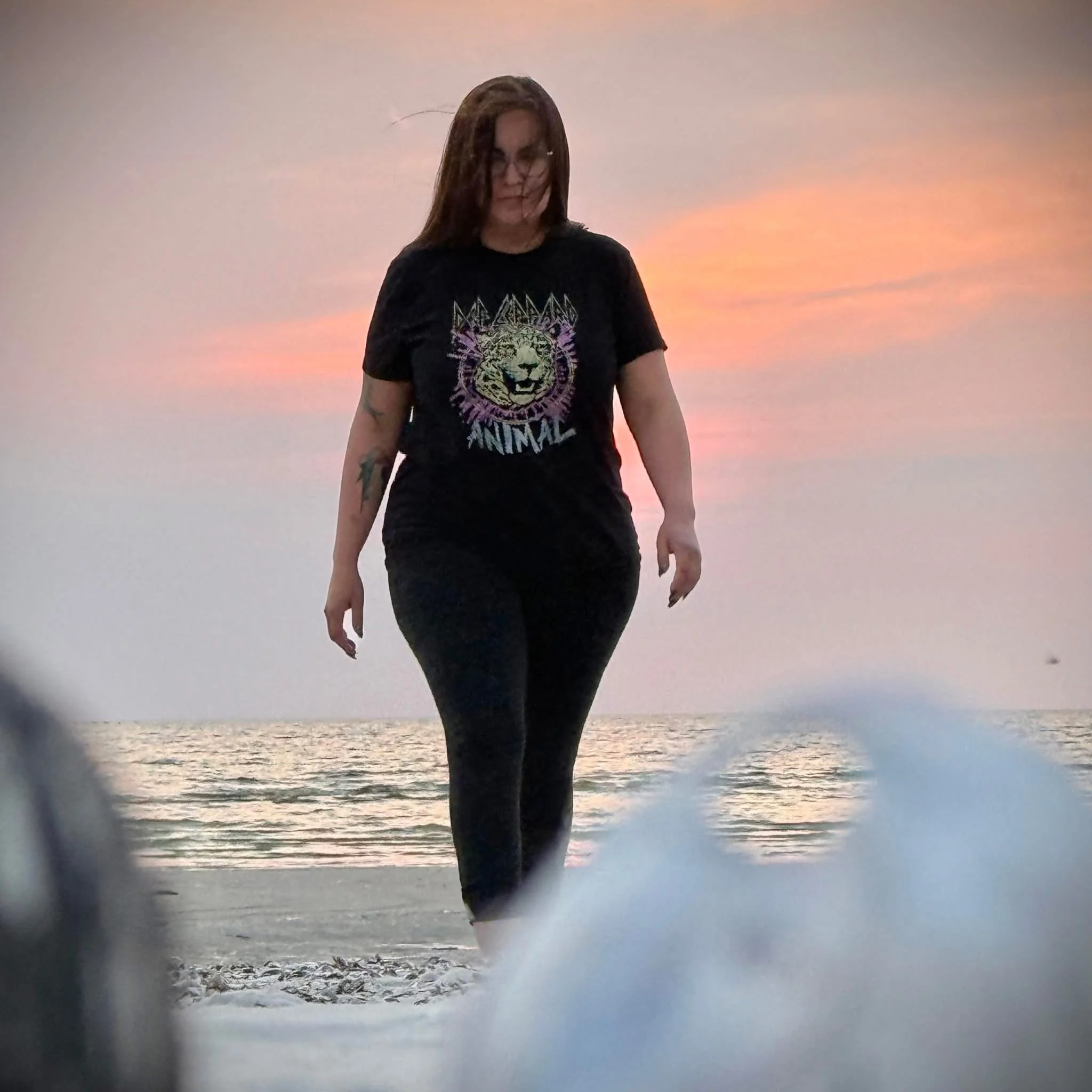 Owner of Ma'iingan Designs walking on the beach at sunset
