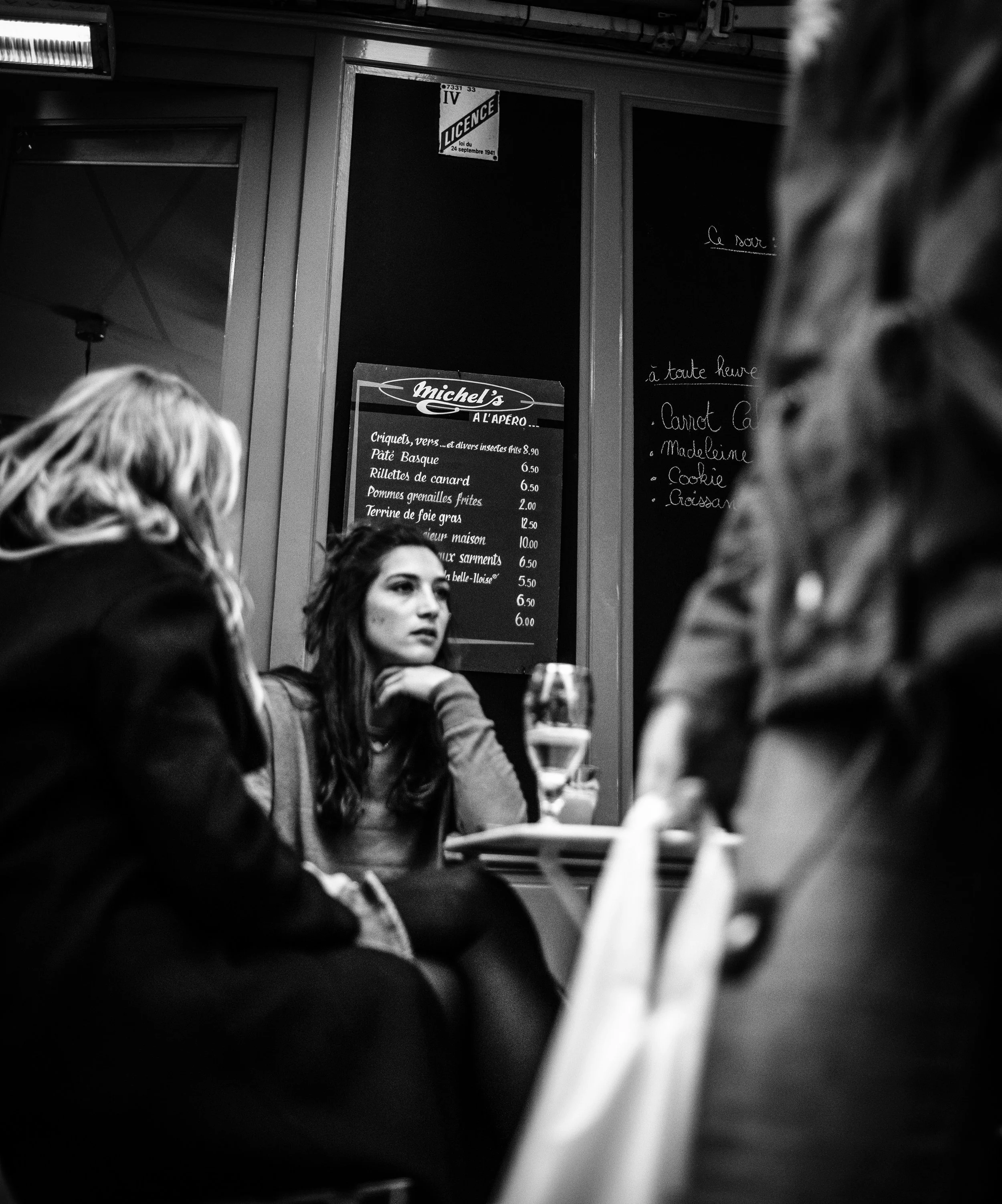Grupo de personas en un restaurante cenando, vista en blanco y negro.