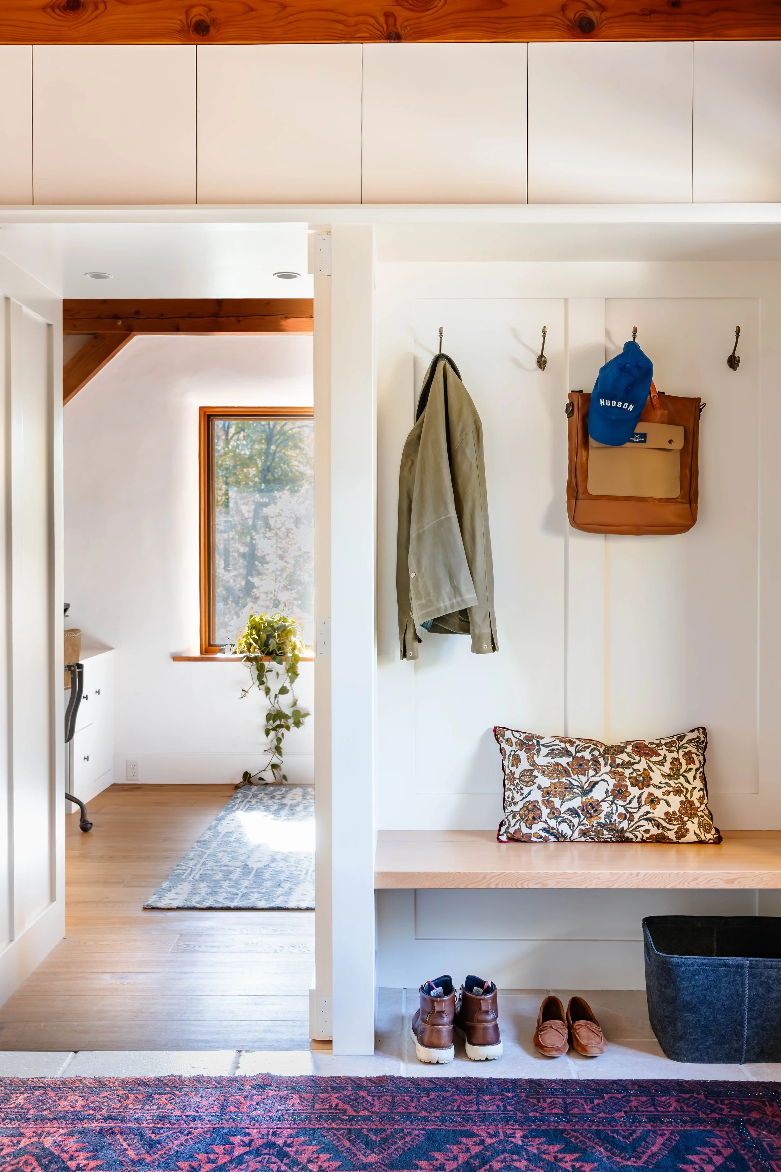 Custom built-in mudroom bench and paneled walls in a straw bale home renovation in New Paltz, NY.