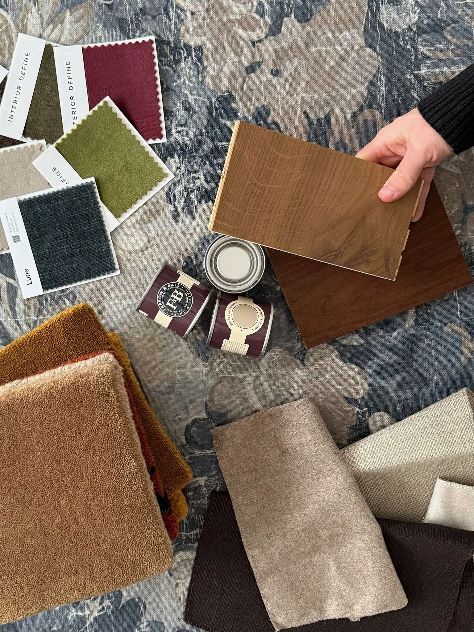 Interior design material selections for a home, including wood finishes, fabric swatches, and paint samples.