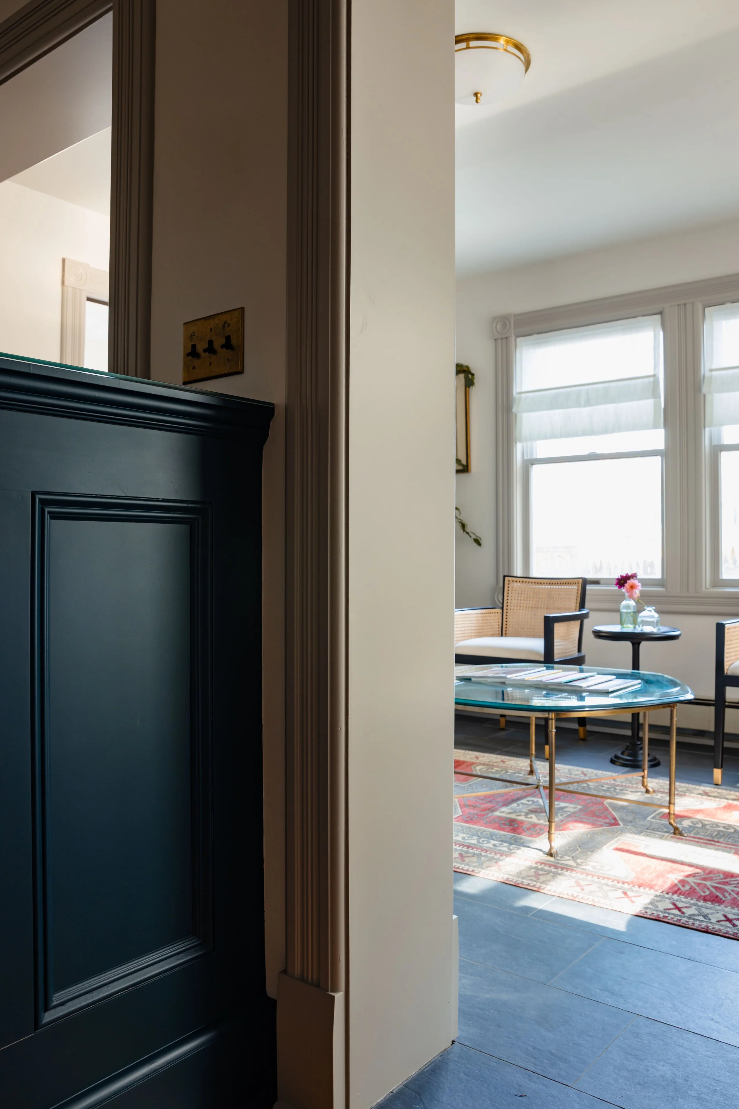 View from private office into client seating area with limestone floors and natural light