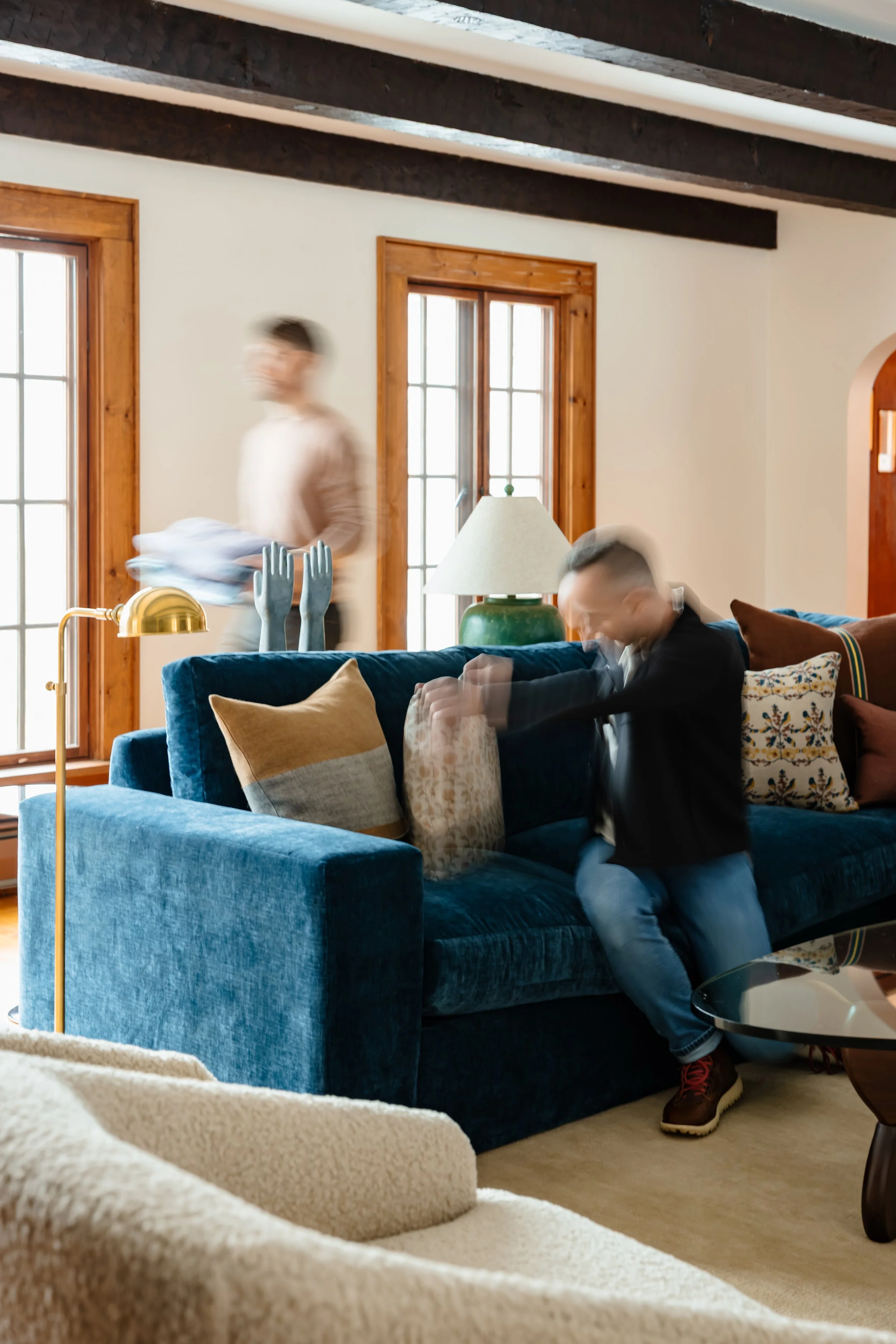 Styled living room moment with blue sofa and blurred movement creating a lived-in feel.