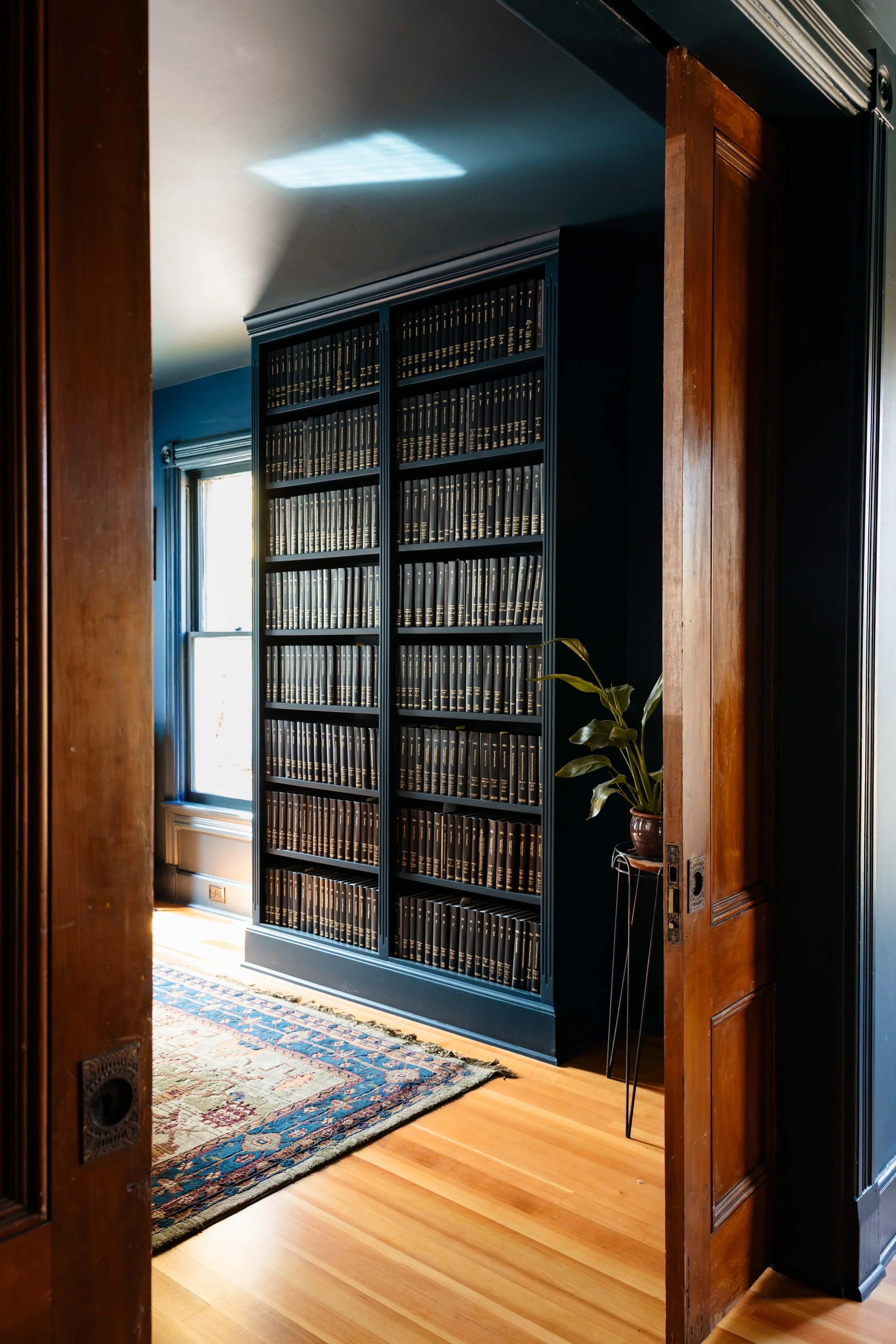 Custom deep blue built-in bookcase filled with vintage law volumes in New Paltz office