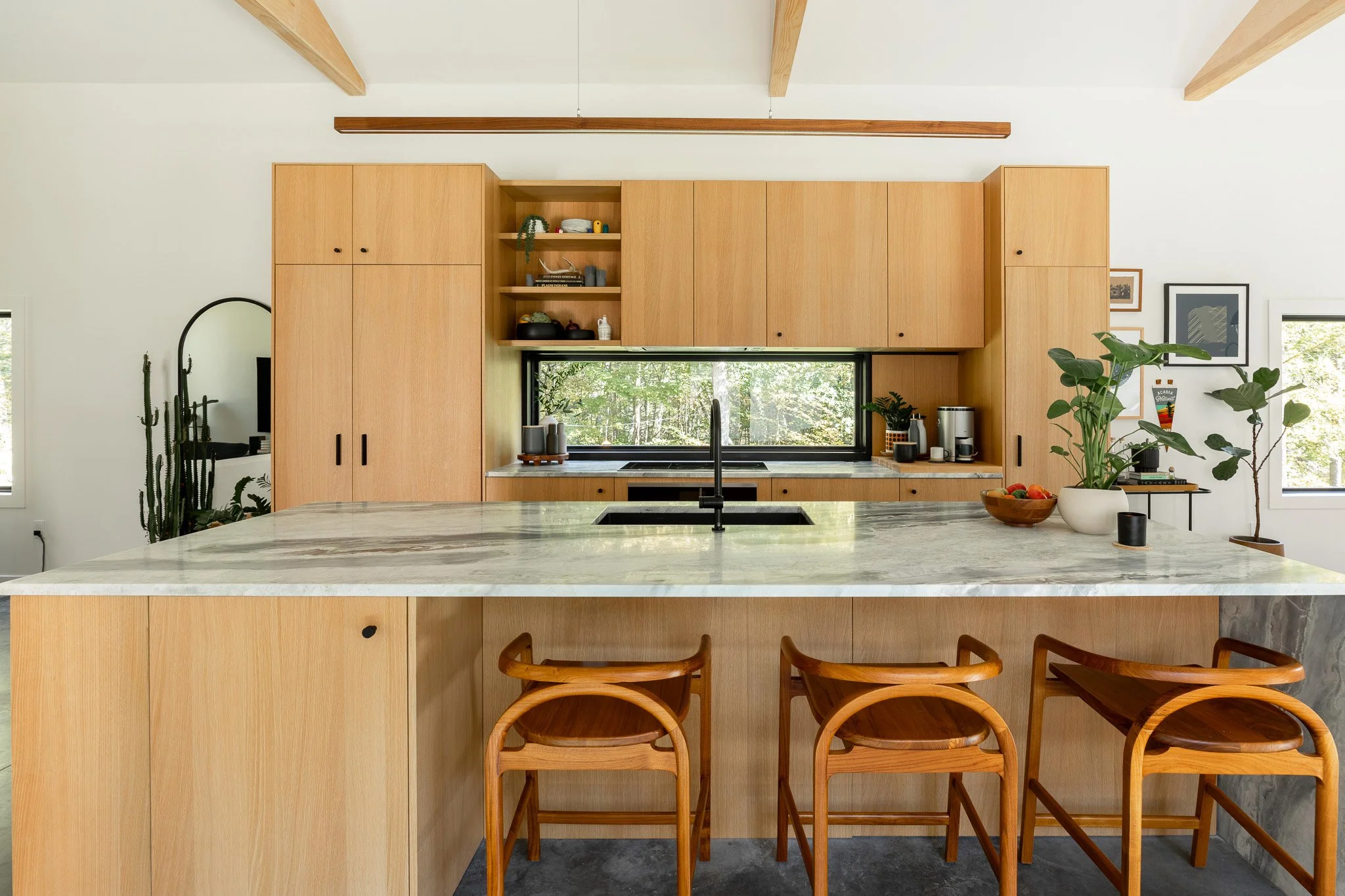 Custom wood kitchen cabinetry with large stone island and integrated sink.