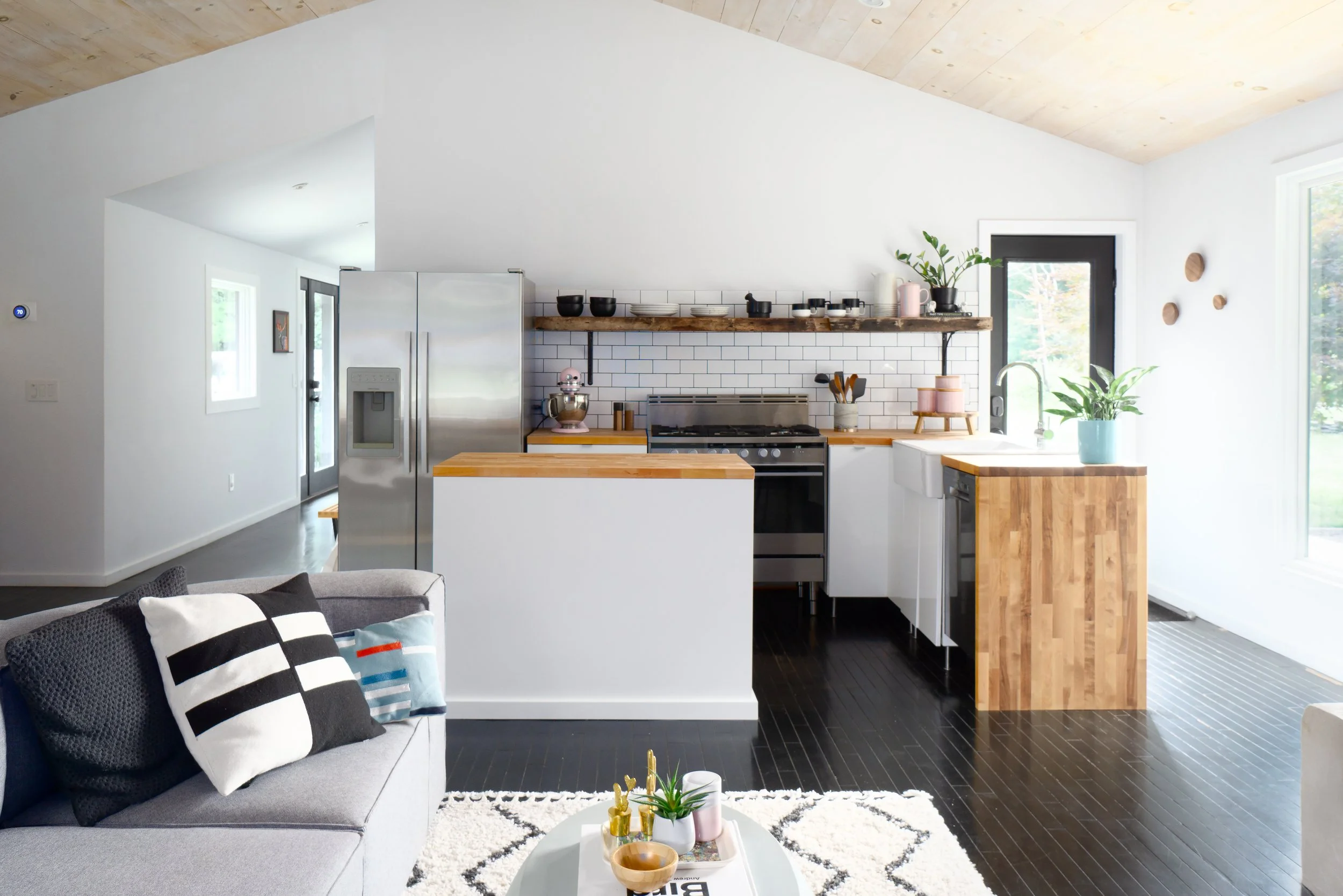 Modern farmhouse kitchen with white cabinetry, butcher block counters, and open wood shelving.