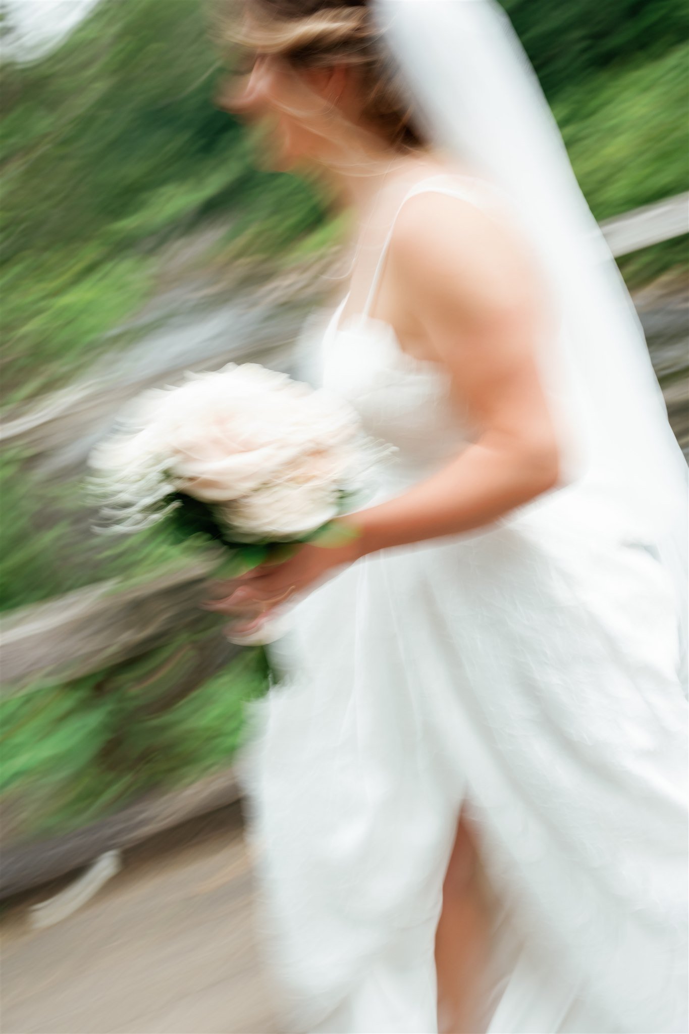 Une femme en robe blanche tient un bouquet de fleurs, floue en raison d'un mouvement ou d'une prise de vue intentionnelle