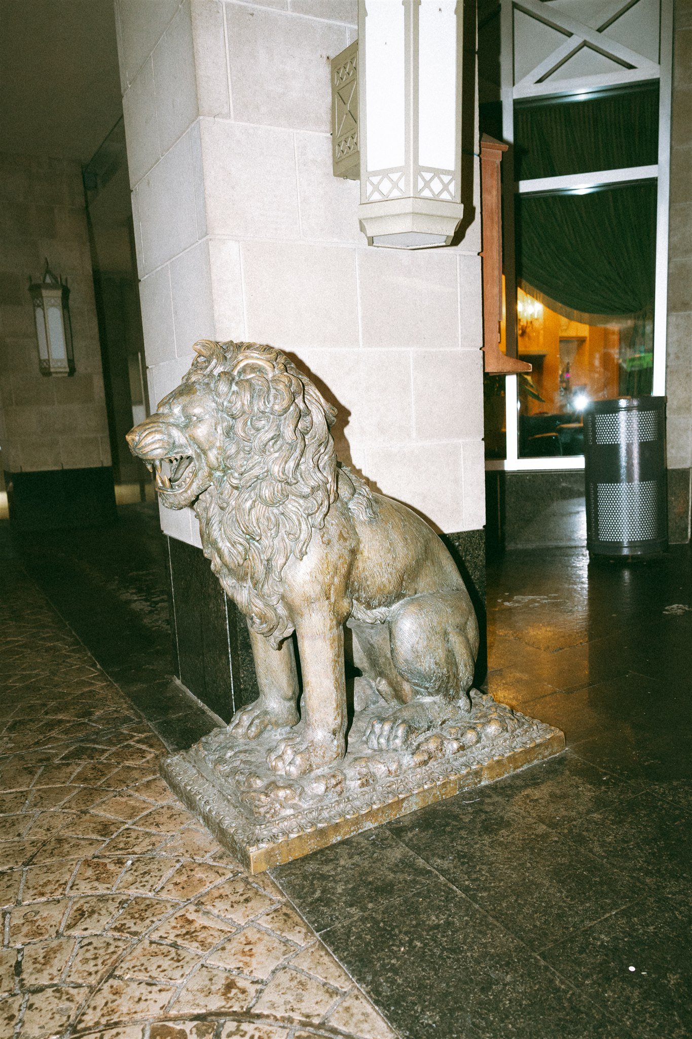 Statue d'un lion en pierre placée au sol.