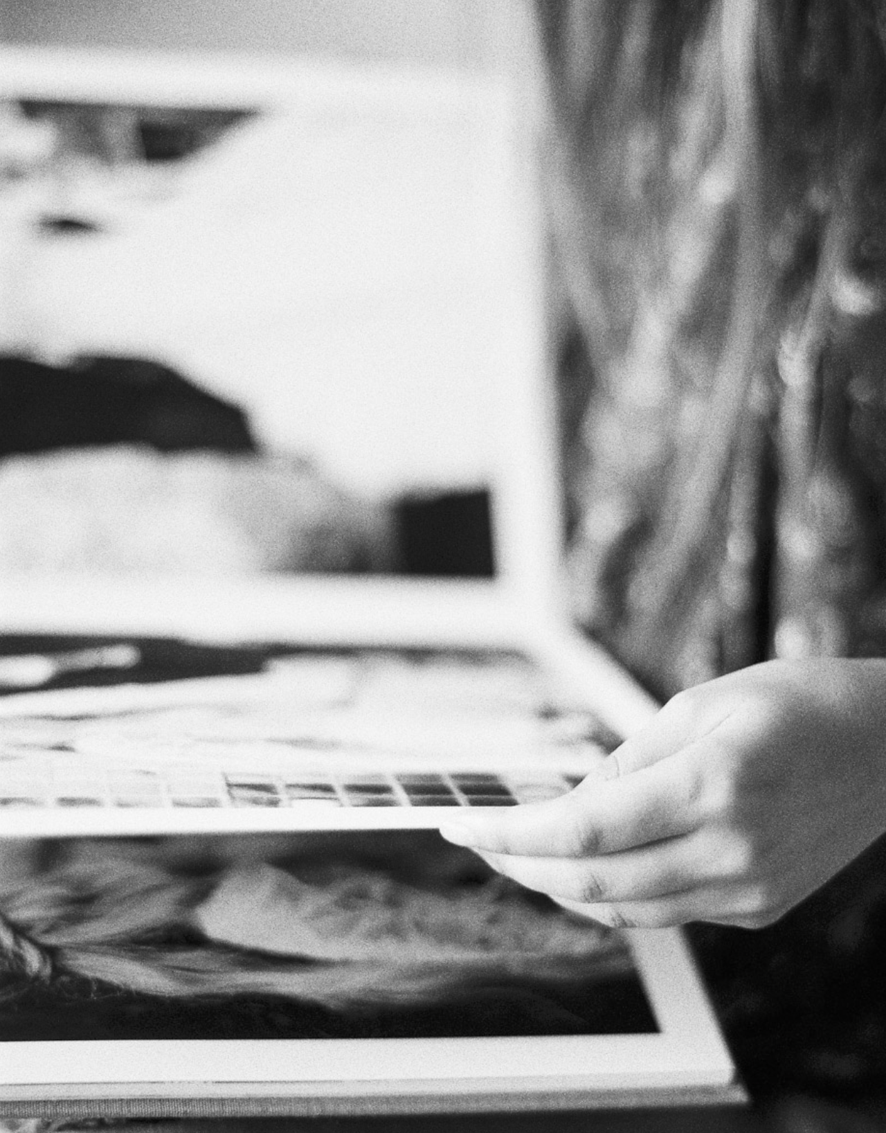 Une main tient une photographie noir et blanc d'une pièce de puzzle, avec un bras d'enfant visible en arrière-plan.