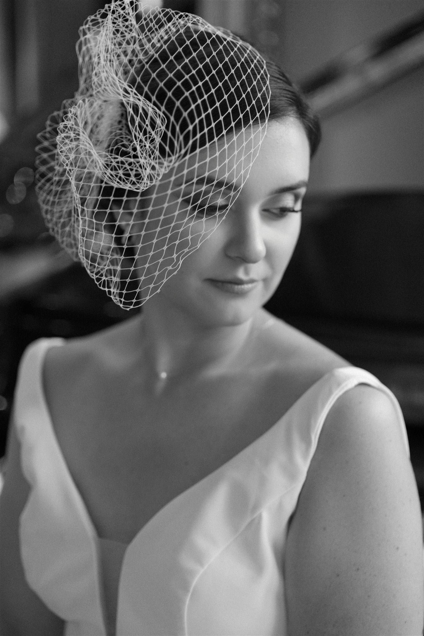 Femme en robe blanche avec voile de mariée en filet regardant doucement de côté, élégante et sereine, captée par un Photographe mariage Québec.