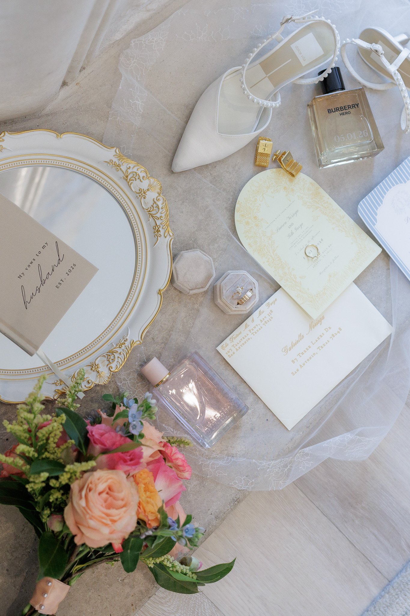Flat lay editorial detail shot including bridal flowers, vows, rings, the brides heels, veil and more shot at the venue, The Arlo, in Austin Texas 