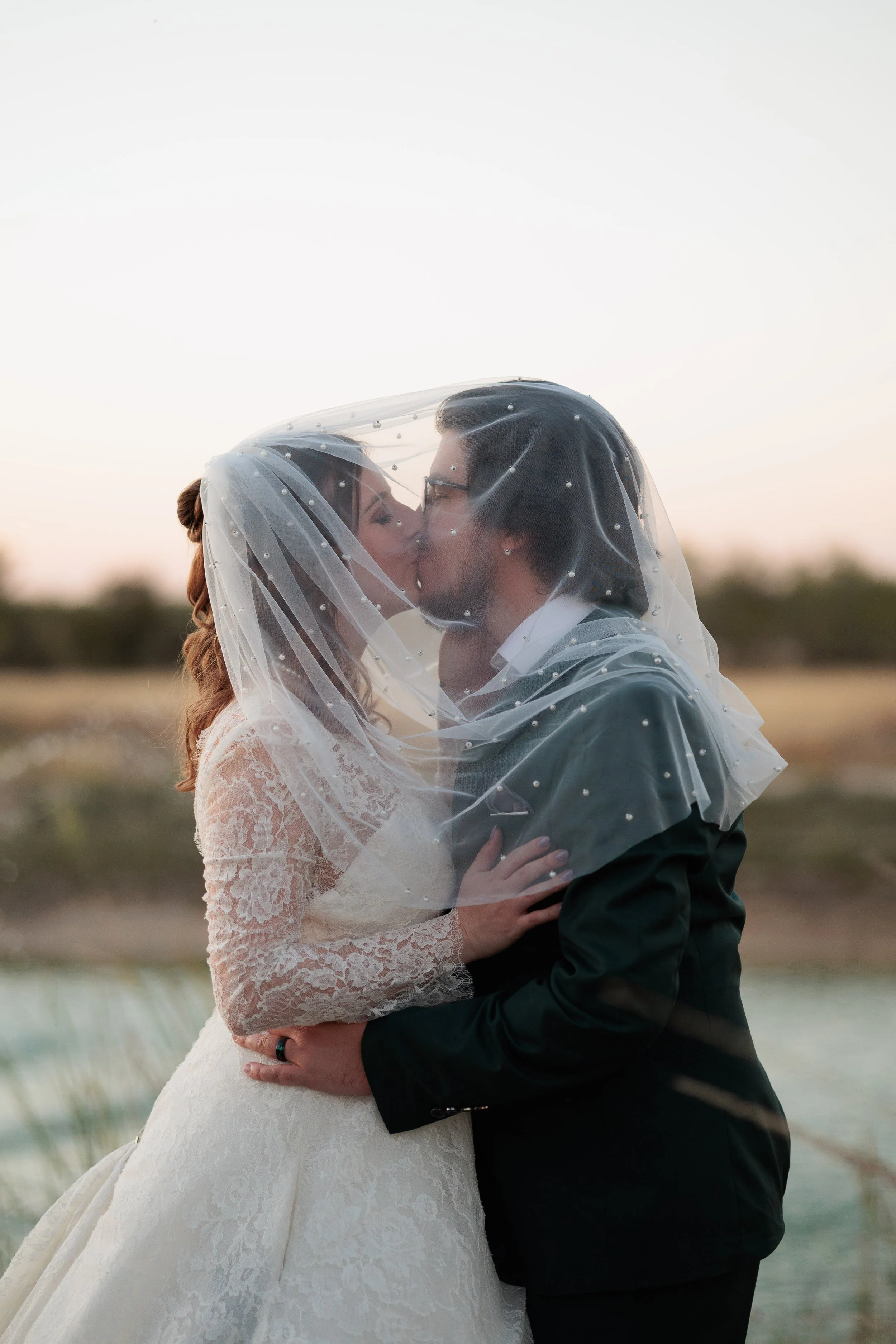 Groom placing the ring on his Bride during wedding ceremony at the Videre Estate in Wimberly Texas