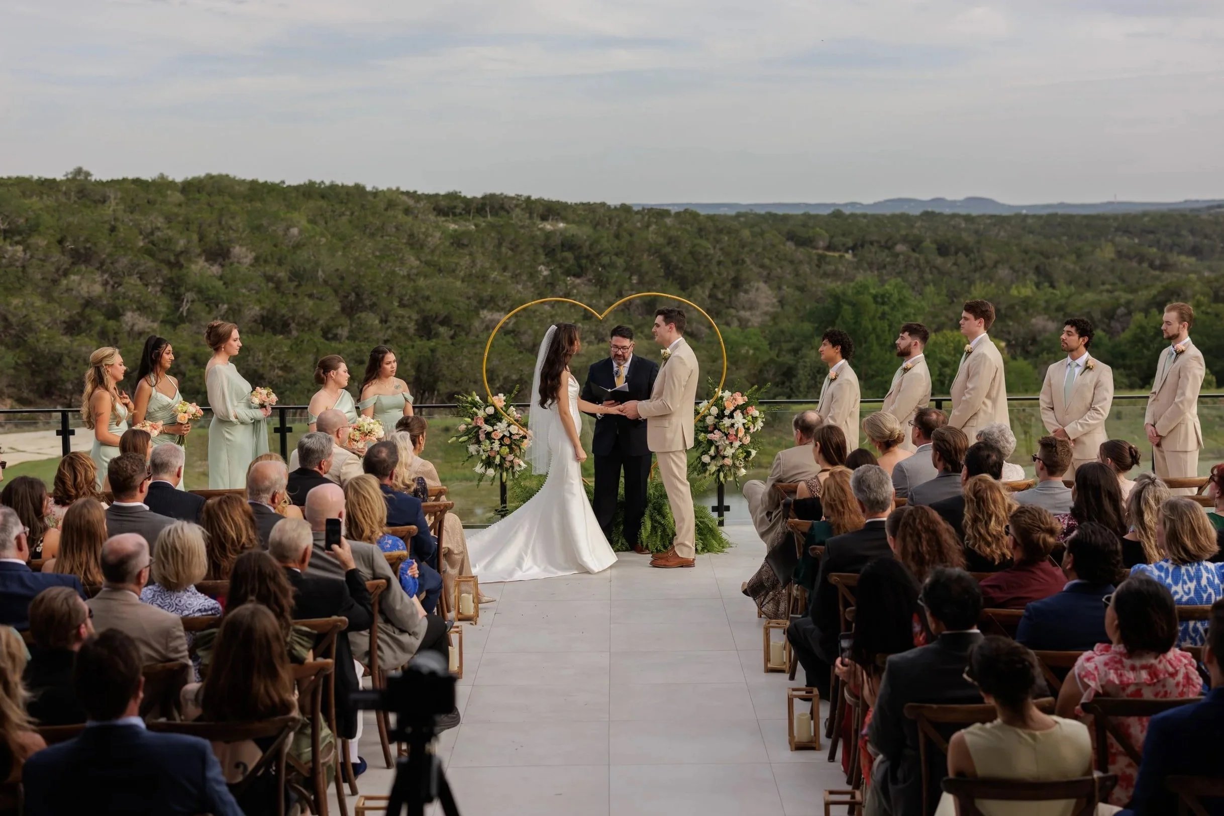 Groom placing the ring on his Bride during wedding ceremony at the Videre Estate in Wimberly Texas