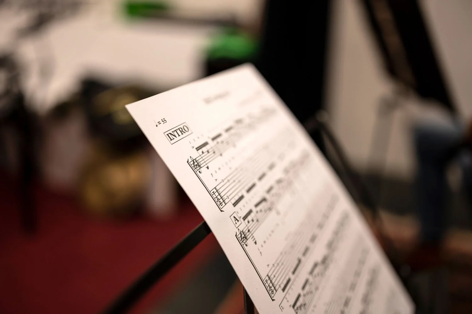 Partition musicale sur un pupitre, avec l'intitulé 'Intro' visible, dans une salle de musique ou un studio.