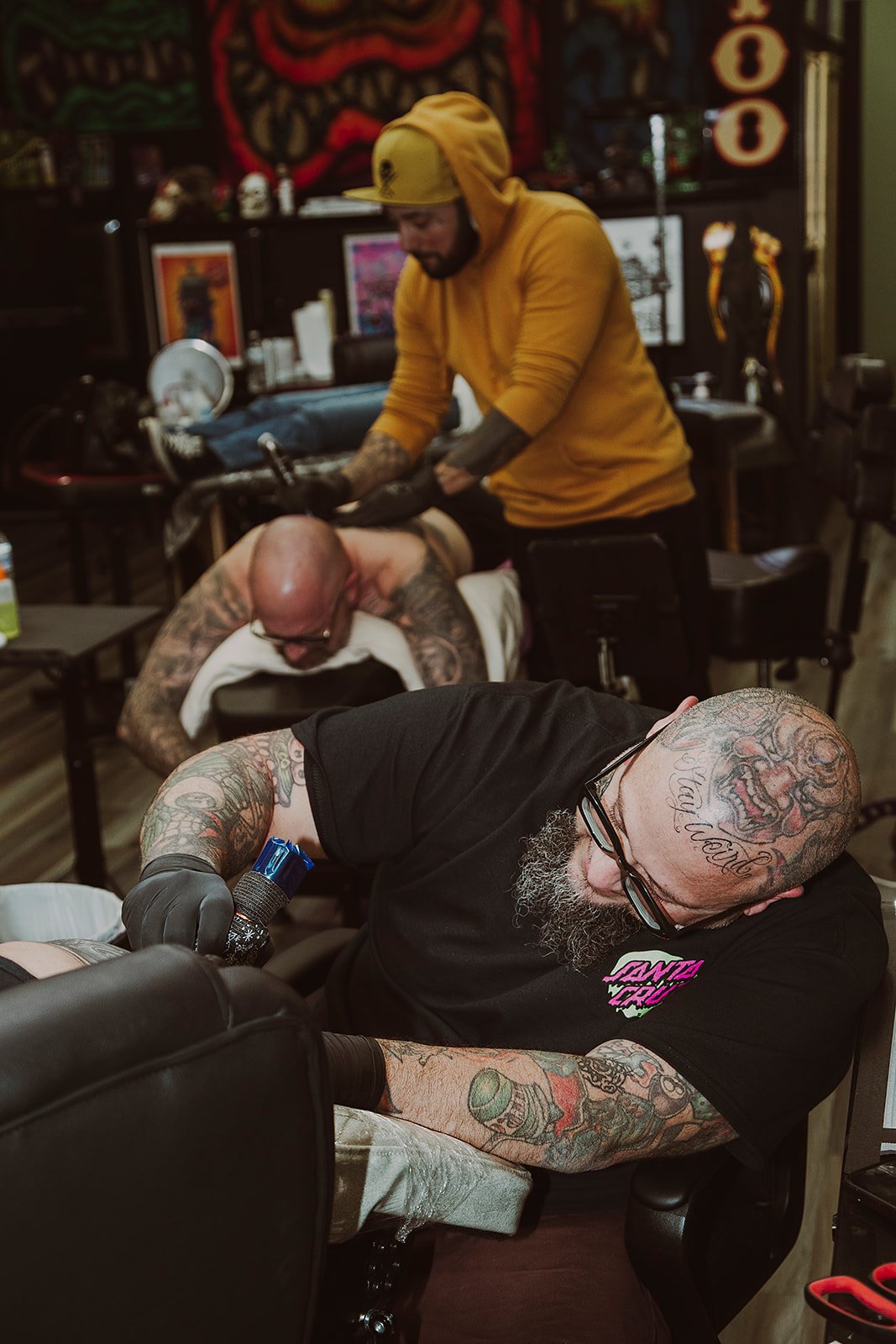 Tattoo artist carefully applying fine-line detail to a client's arm at Ink & Iron Tattoo Shop in Midlothian, Virginia.