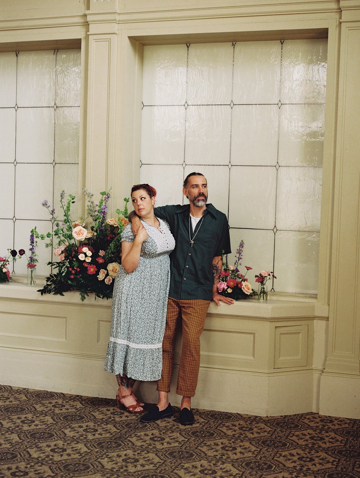 A woman in floral dress posed with a tattooed man
