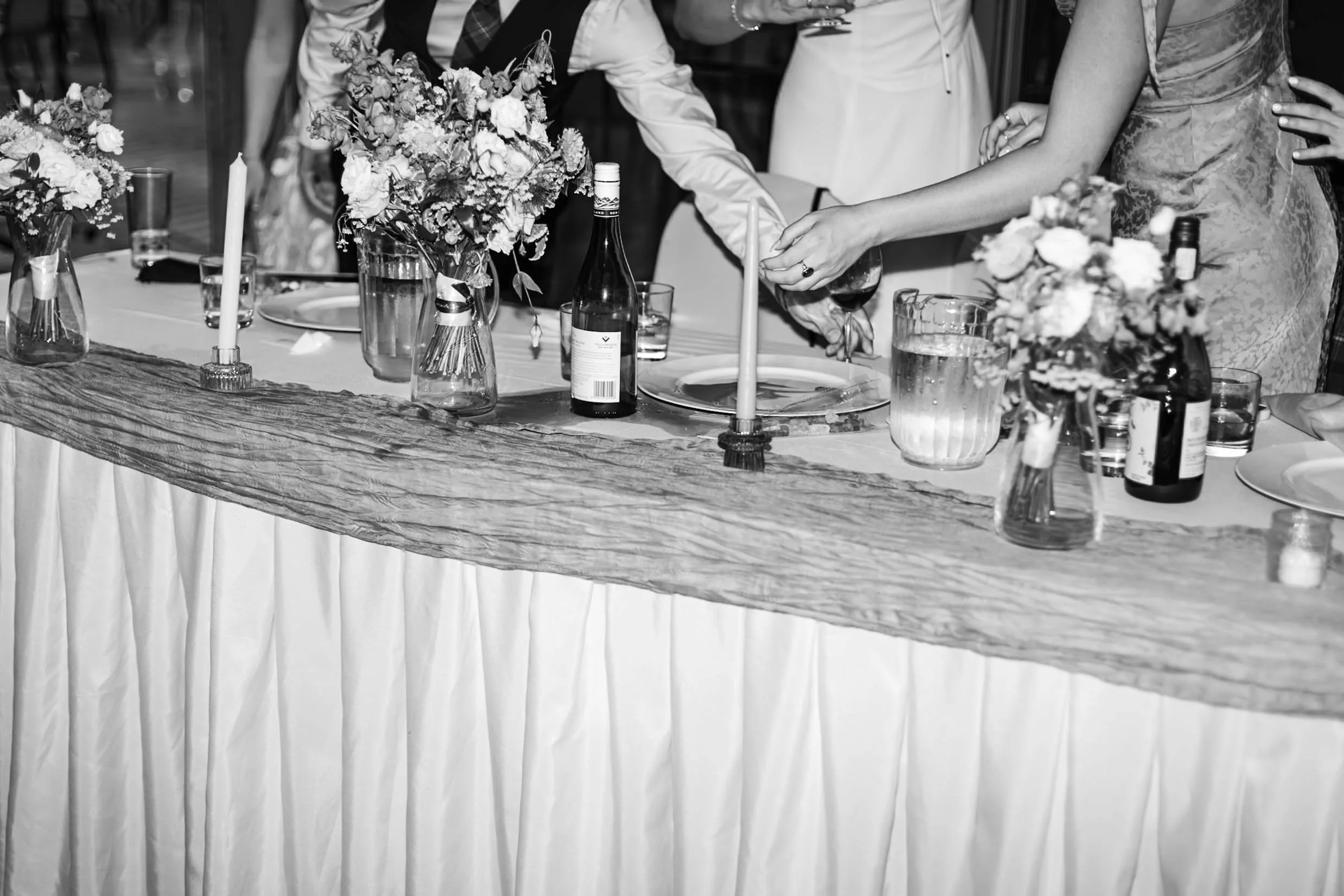 Black and white photo of head table during wedding at Bill Warren training Centre in Canmore, Alberta