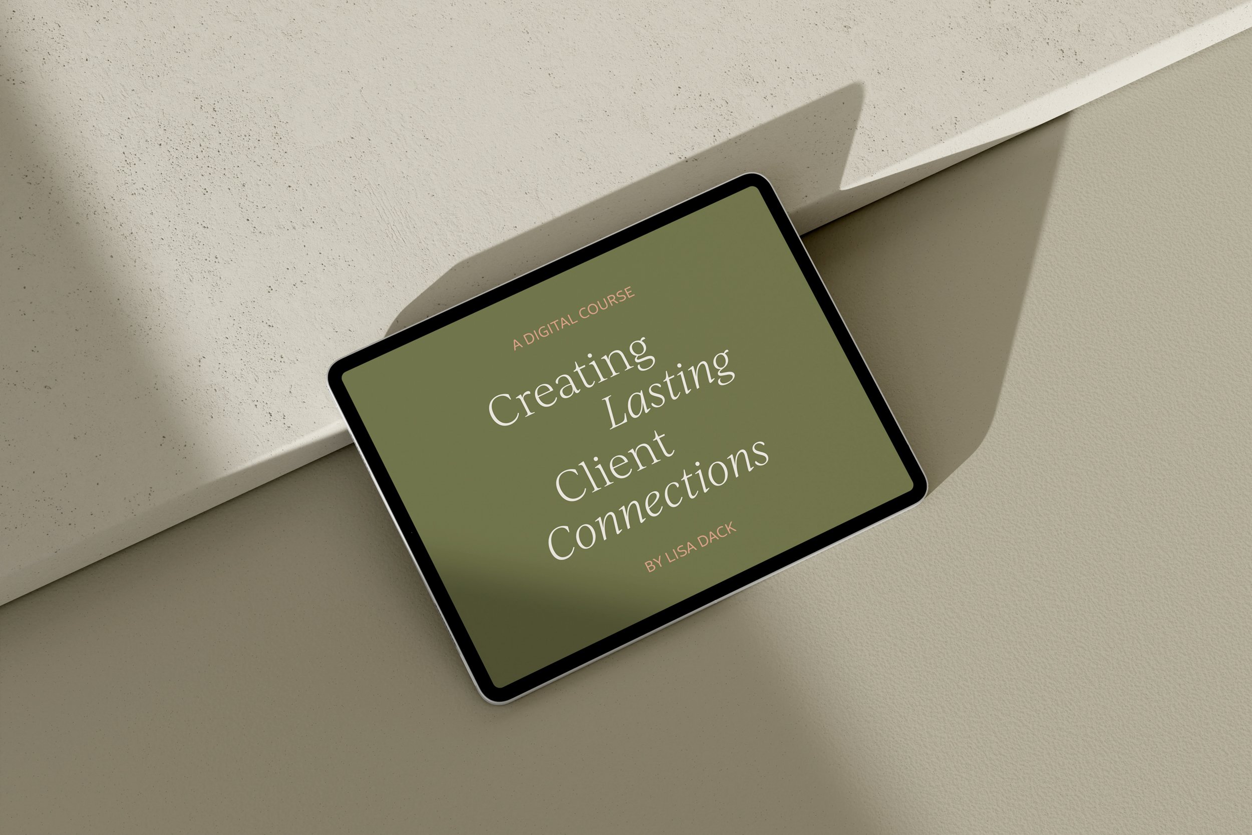 A tablet laying on a beige surface displaying a digital course titled "Creating Lasting Client Connections" by Lisa Dack.