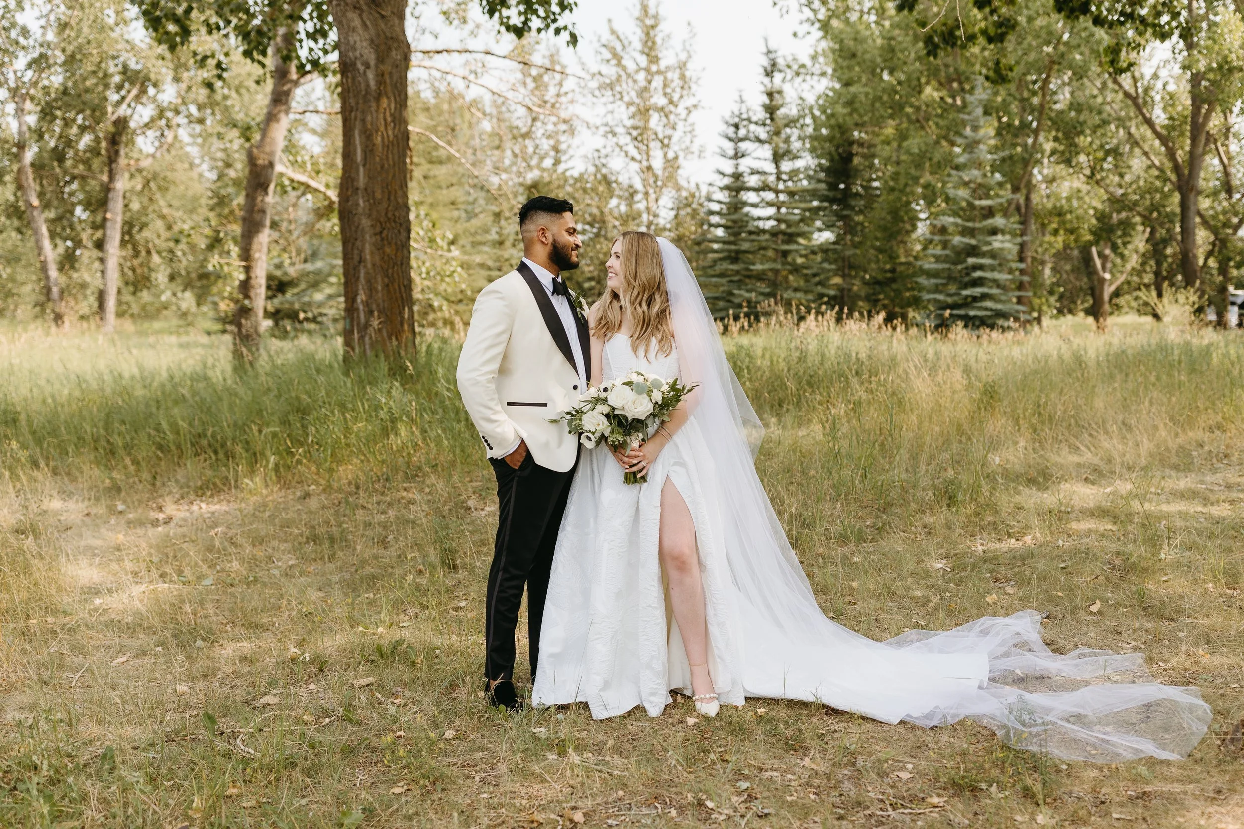 Portrait of bride in modern dress and groom in white tuxedo at Fish Creek Park in Calgary