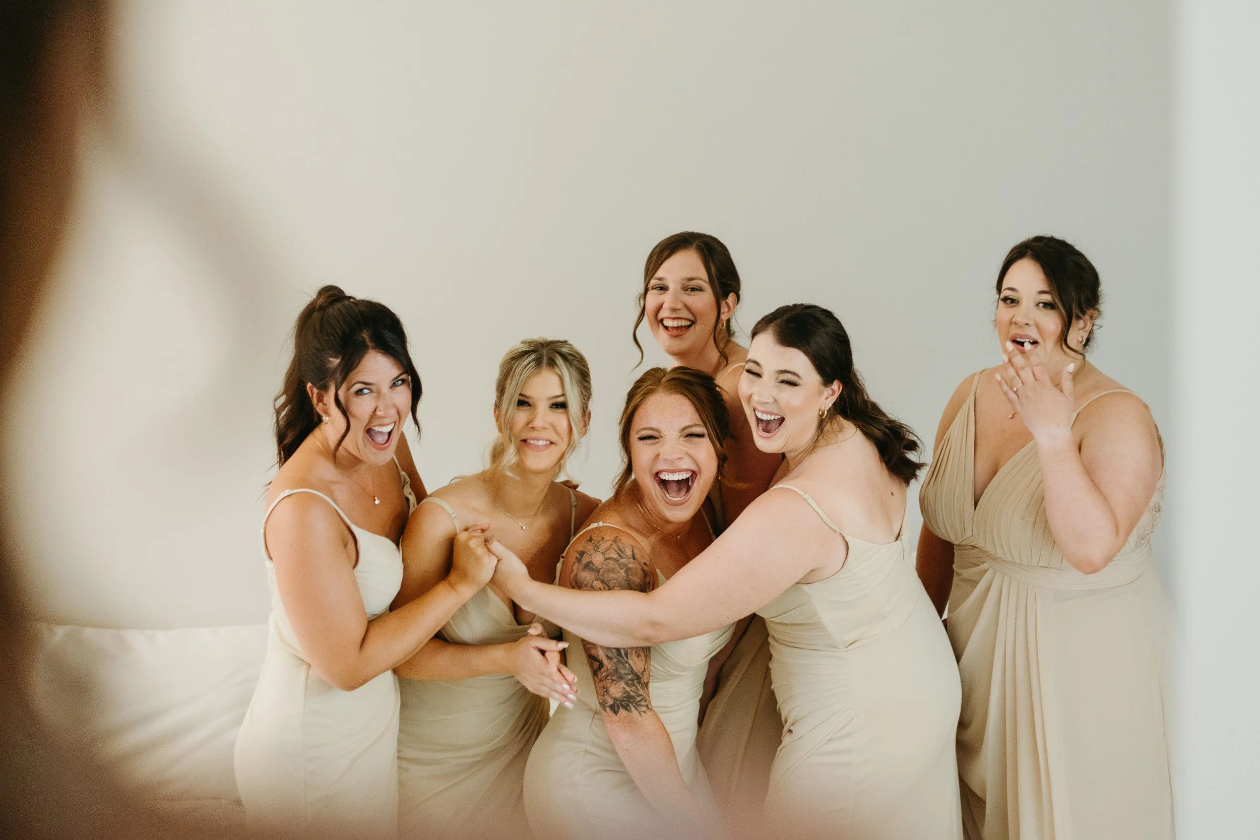 Bridesmaids in gold mismatches dresses react to seeing the bride on the morning of the wedding in Calgary
