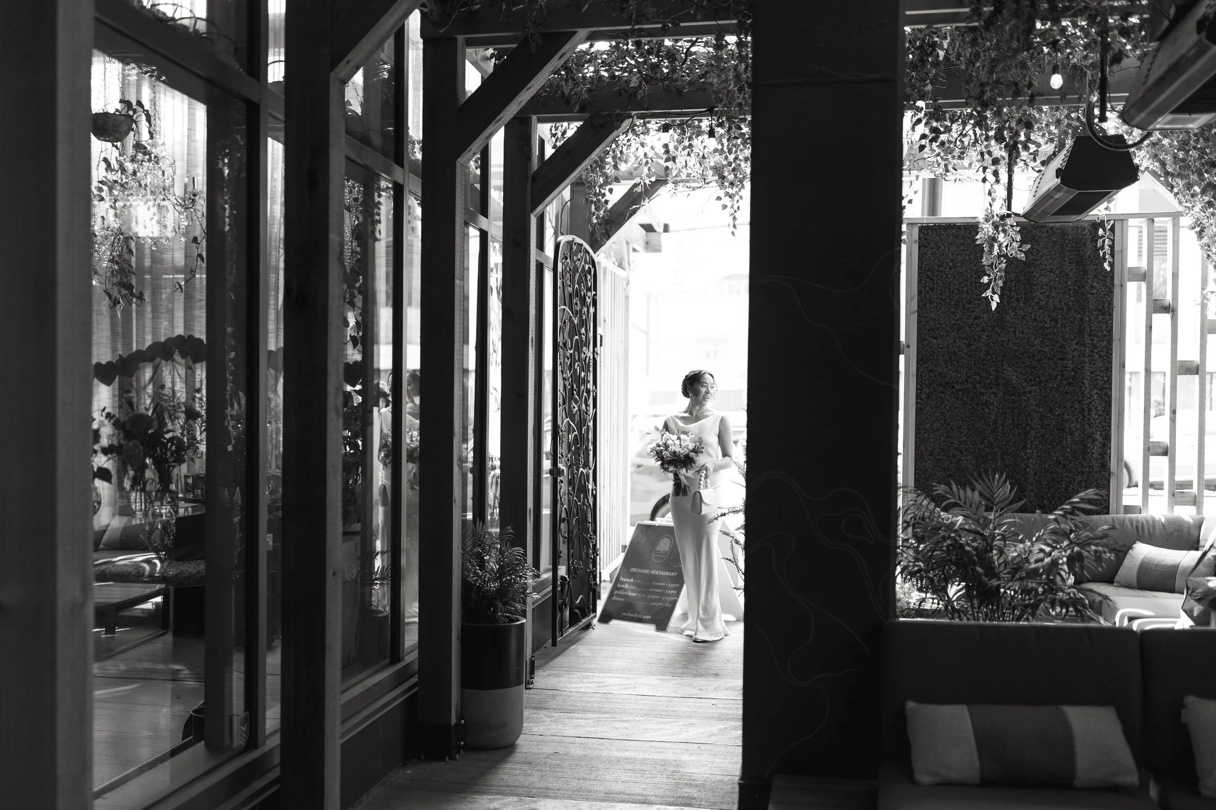 Documentary black and white wedding photo of bride walking into her wedding at Orchard Restaurant in Downtown Calgary