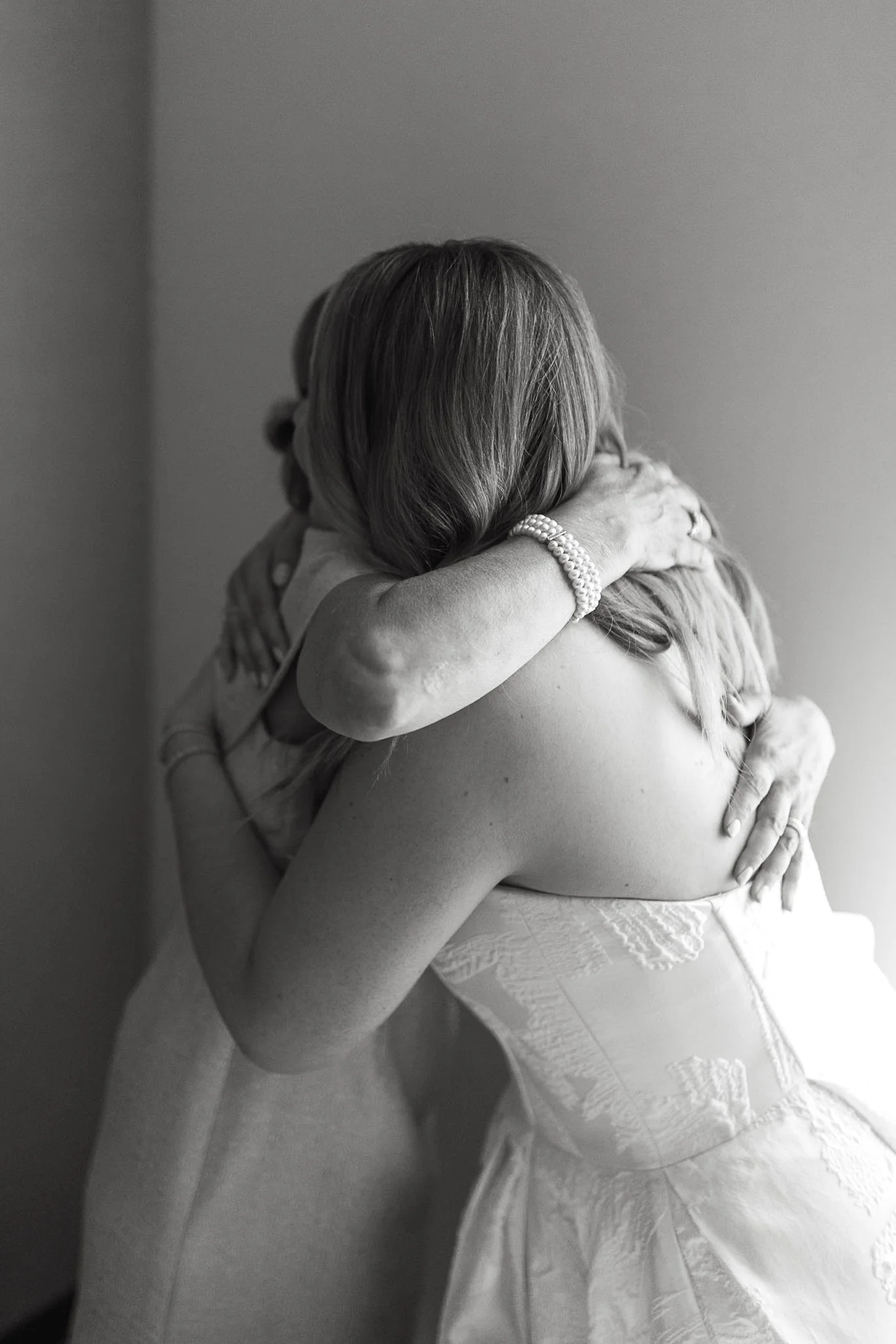 Emotional black and white image of bride hugging her mom on the morning of her wedding 