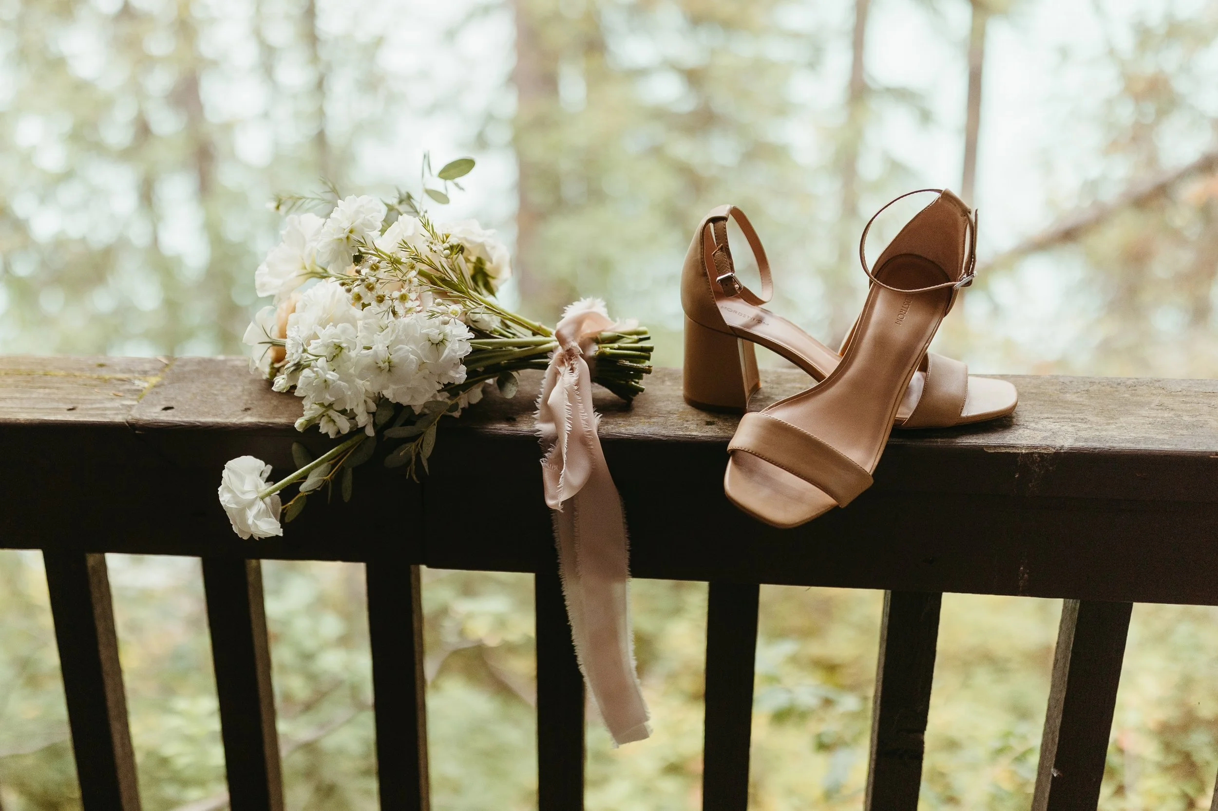 Detail photo of bridal bouquet and nude coloured heels on balcony at Emerald Lake Lodge