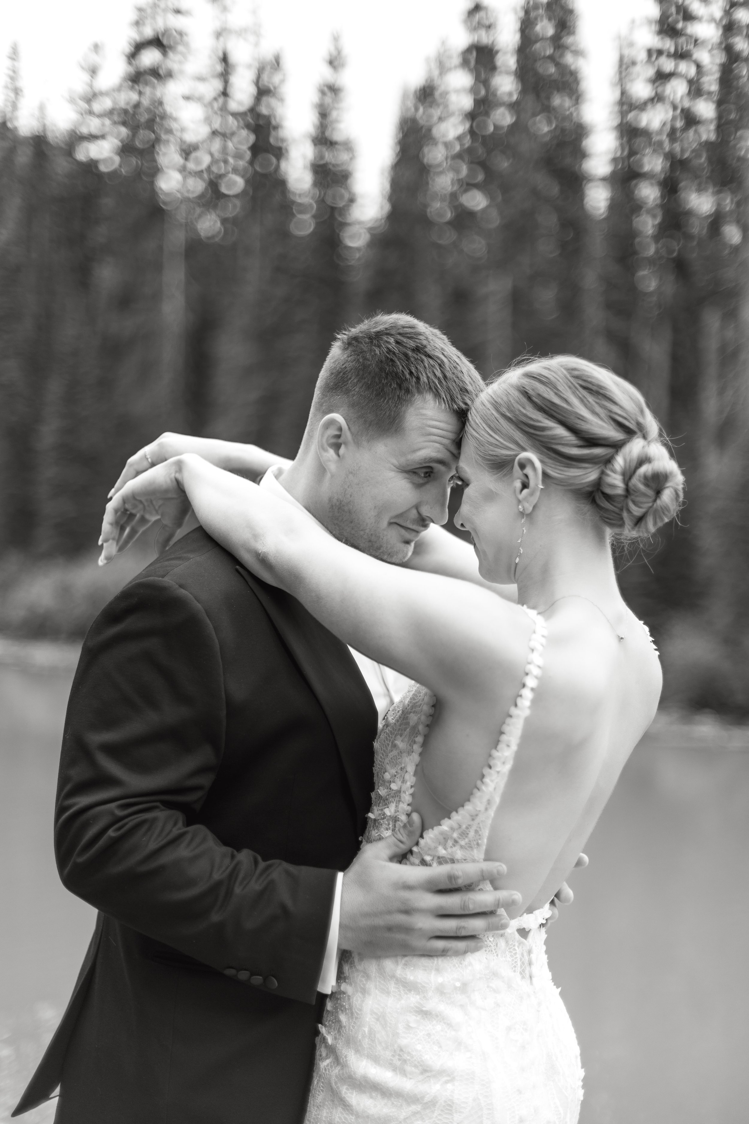 Black and white photo of bride and groom kissing during their wedding reception at Emerald Lake Lodge in Canada