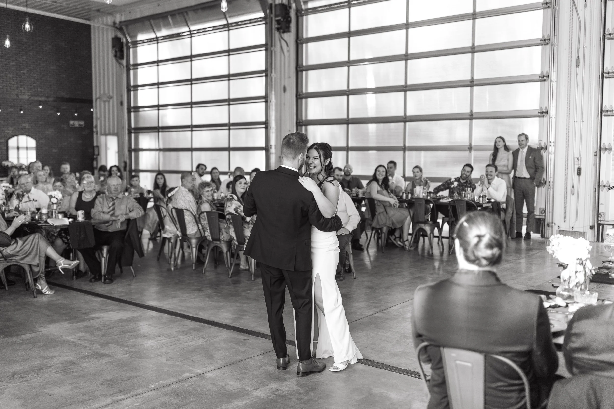 Black and white photo of couple sharing first dance during their wedding reception at 52 North Wedding Venue in Sylvan Lake, Alberta