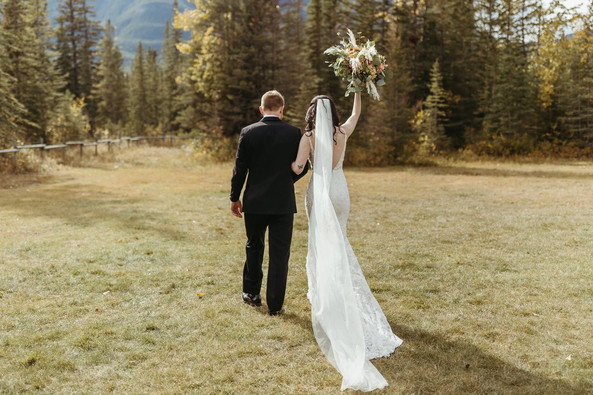 Bride and groom cheer as they walk out of their wedding ceremony in Canmore, Alberta