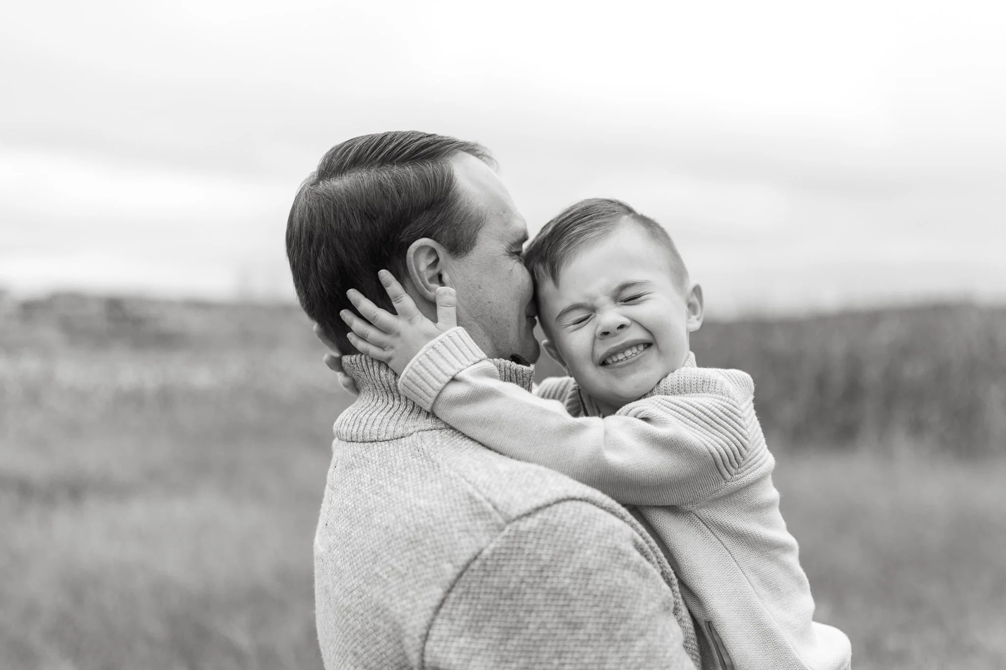 Candid black and white photo of father and son during family session in Calgary, Alberta