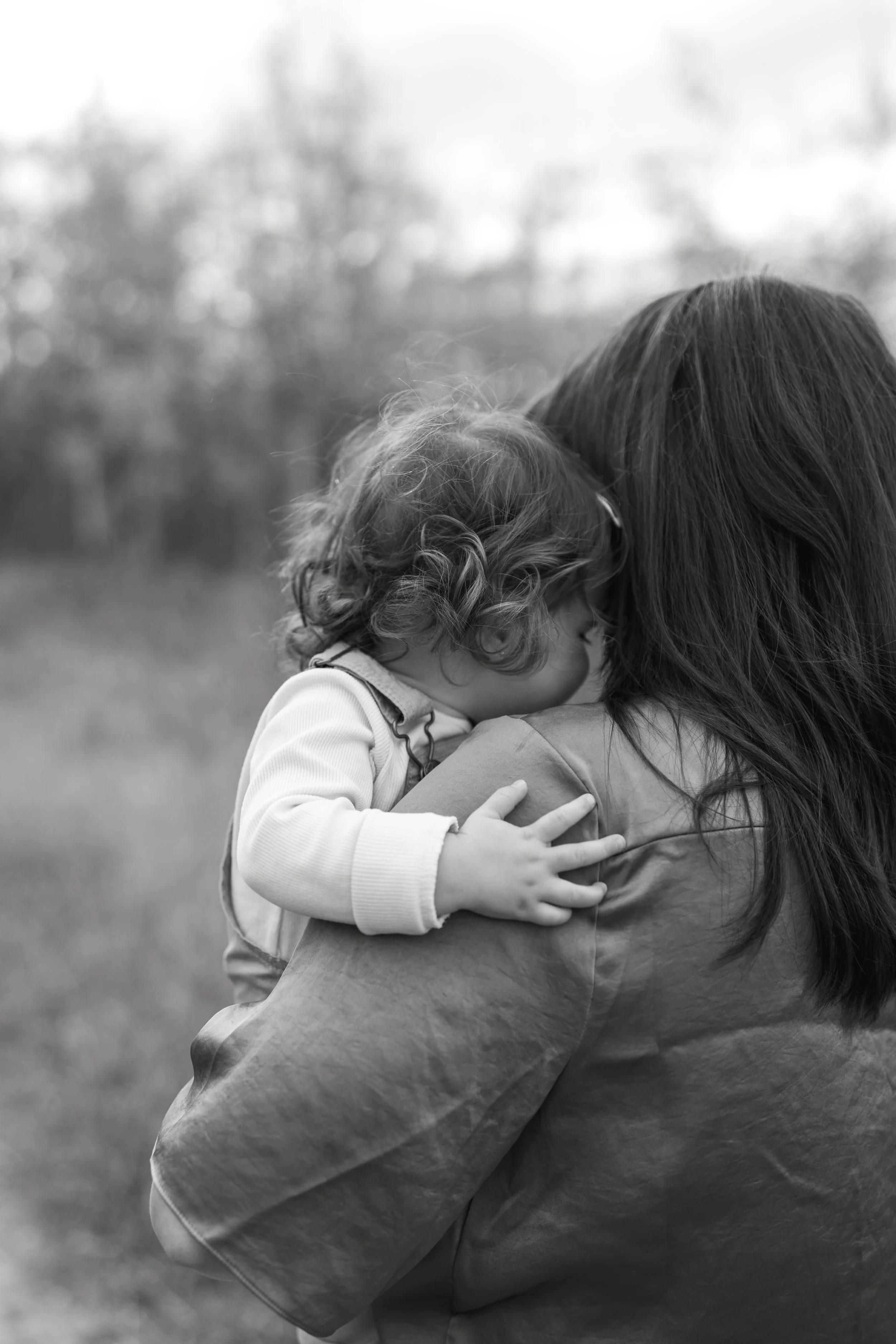 Emotional black and white image of mother holding her baby daughter in Calgary 