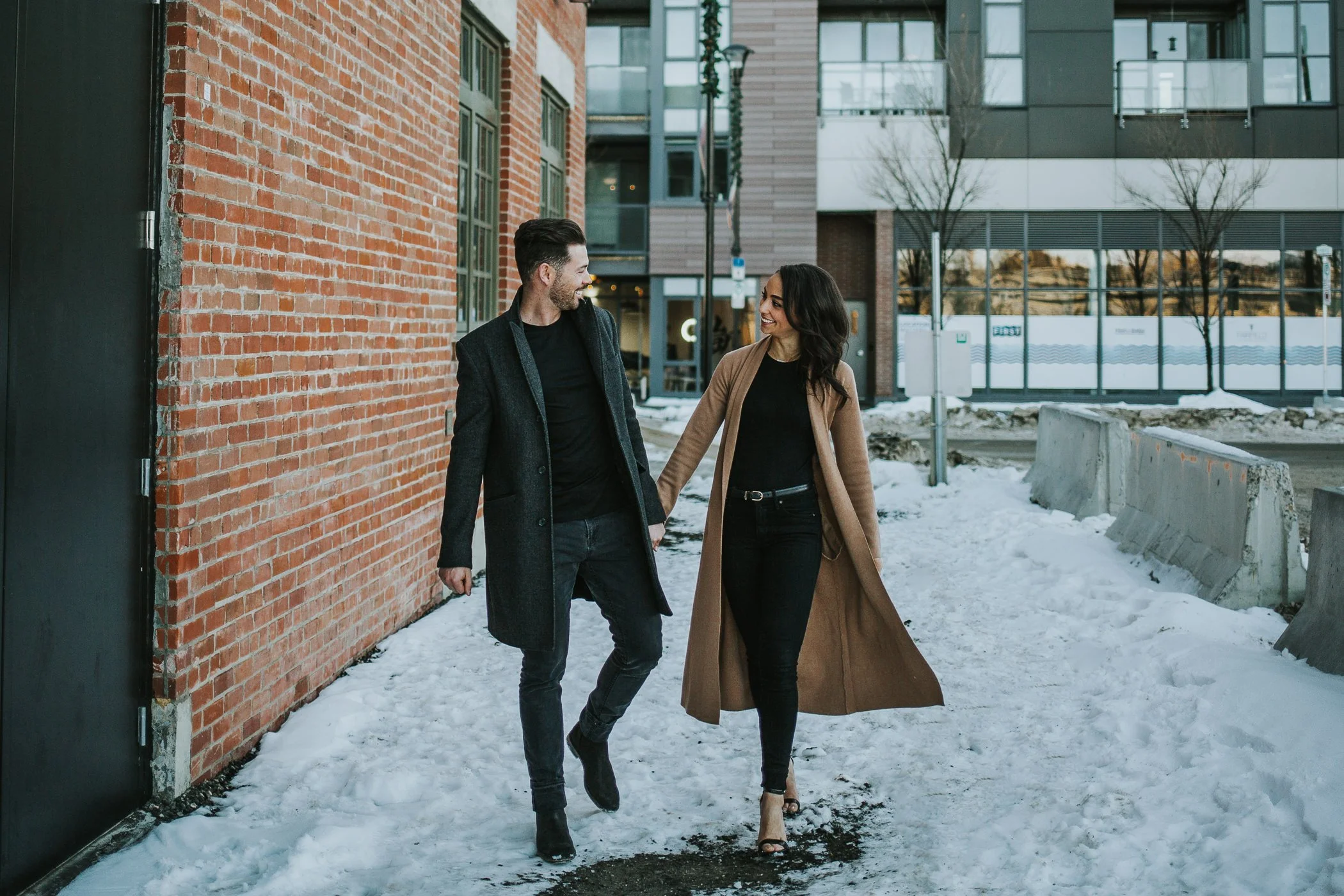 Couple walking together laughing at their downtown Calgary engagement session